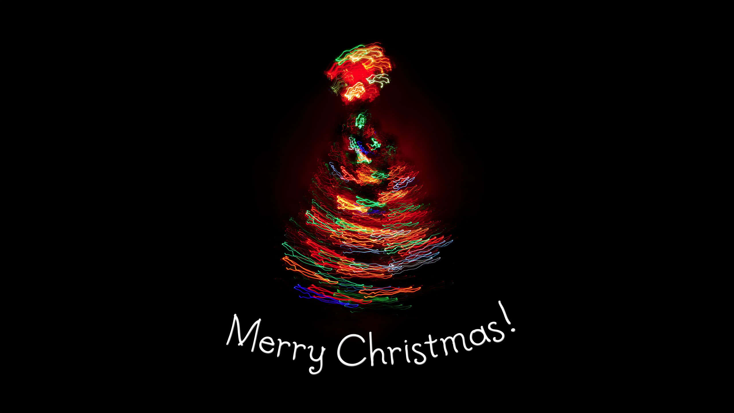 1920x1080 HD Christmas 桌布 壁紙 — 一幅充滿活力的光繪聖誕樹，在黑色背景上閃爍著旋轉的紅色、綠色和藍色光跡，並帶有「聖誕快樂！」文字。