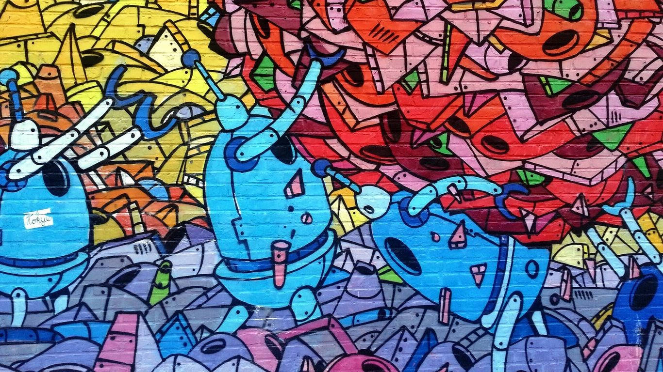 藝術 桌布 壁紙 — 一幅充滿活力的塗鴉壁畫，描繪了風格化的藍色機器人，置身於色彩繽紛的幾何形狀和抽象形態的混亂爆發之中。