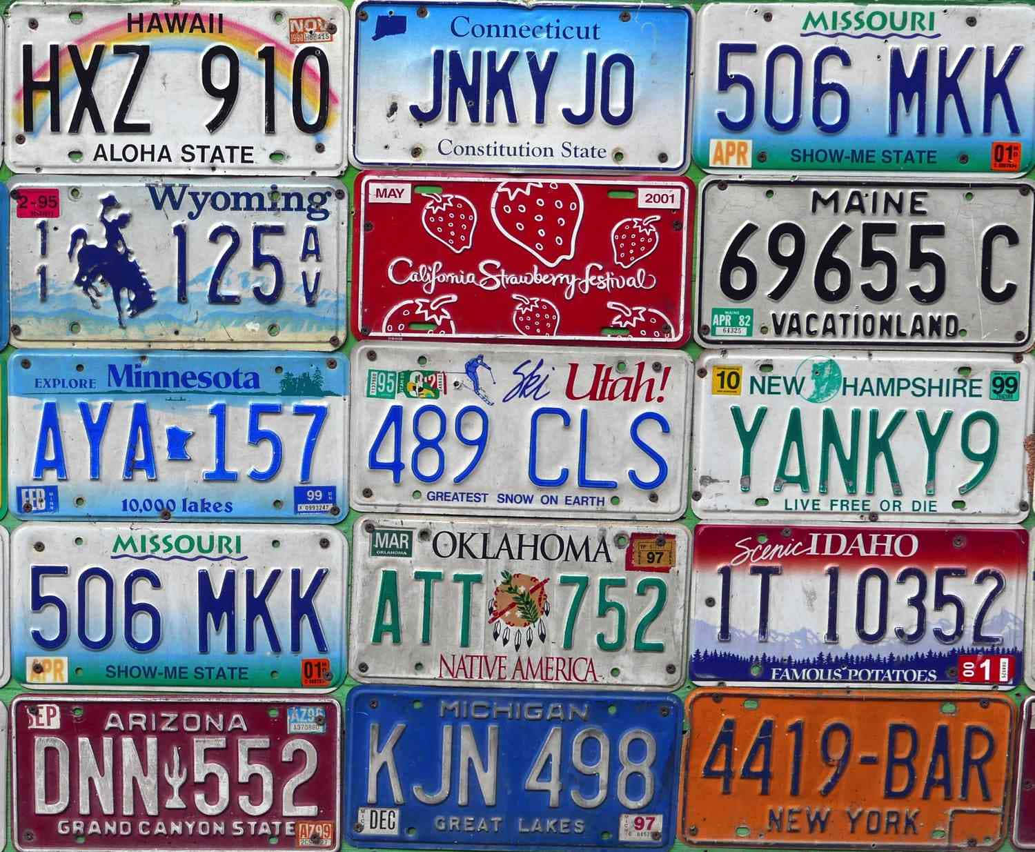 License Plate 桌布 壁紙 — 一幅充滿活力的拼貼畫，展示磨損的美國各州車牌，體現地區自豪感和古怪標語。