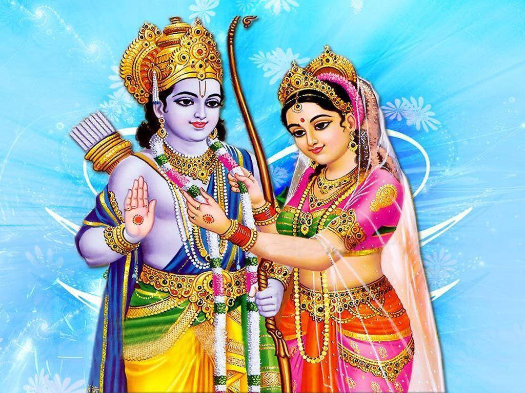 Sita 桌布 壁紙 — 一幅充滿活力的插圖，描繪了羅摩勛爵和西塔，他們戴著金色王冠，穿著色彩繽紛的傳統服飾，背景是帶有花卉圖案的燦爛藍色。
