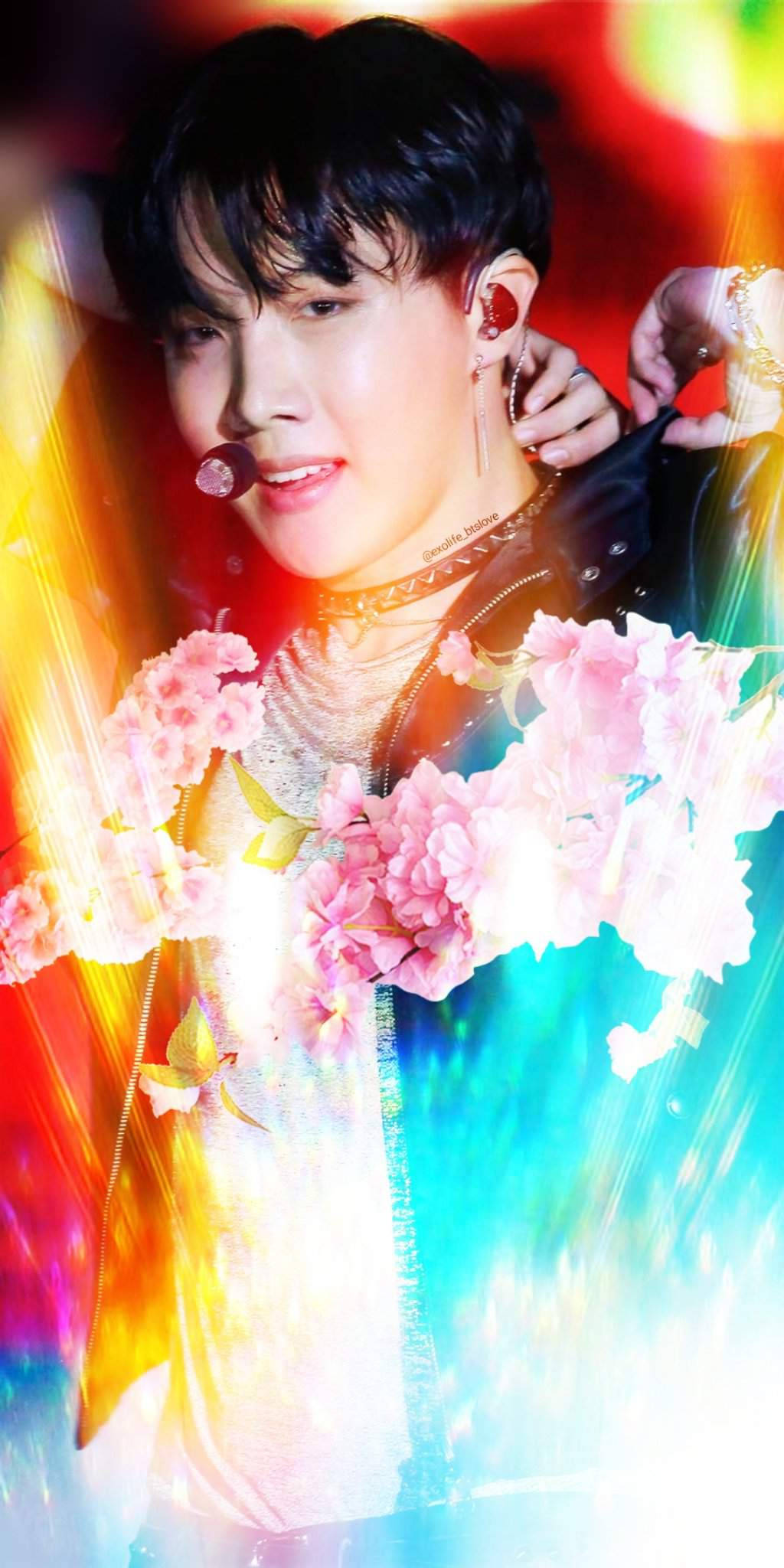 jhope 桌布 壁紙 — 一幅充滿活力的男性表演者肖像，周圍環繞著粉紅花朵和彩虹光線。