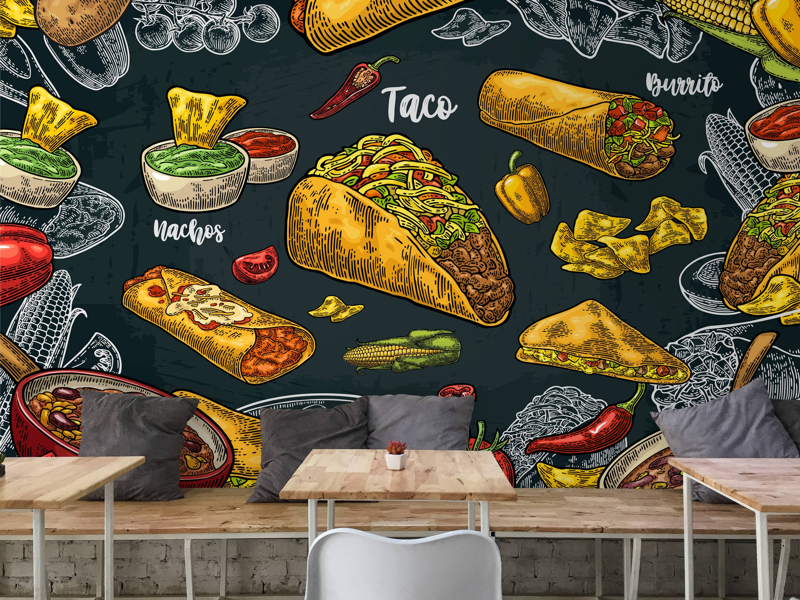 Taco 桌布 壁紙 — 一幅充滿活力的粉筆風格壁畫，描繪了墨西哥美食如玉米餅、捲餅和玉米片，裝飾在木桌和灰色靠墊後面的深色牆壁上。