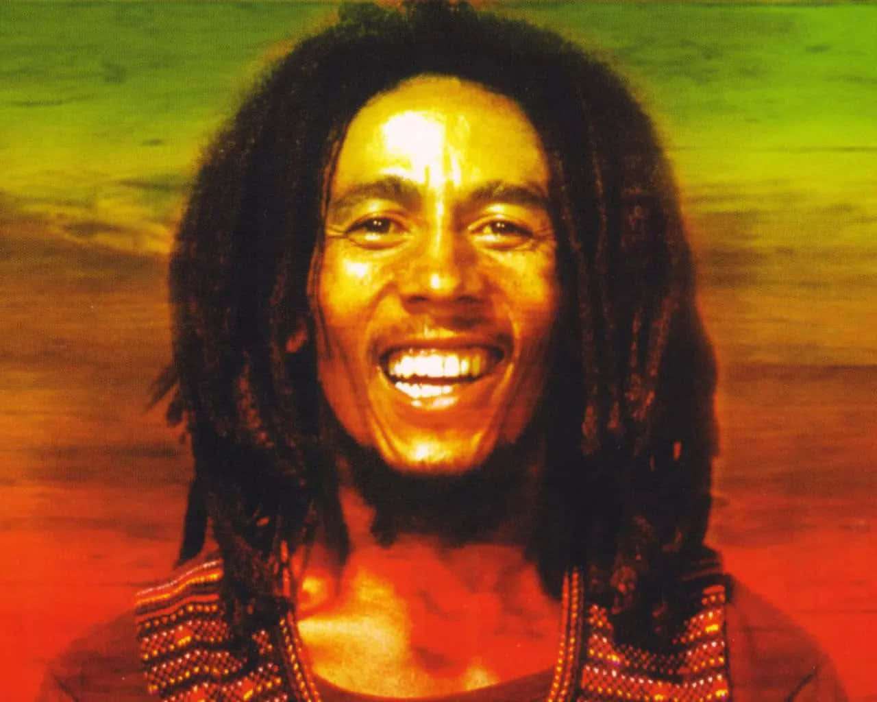 Bob Marley 桌布 壁紙 — 一幅充滿活力的肖像，鮑勃·馬利在綠色和橙色的漸變背景上燦爛微笑。