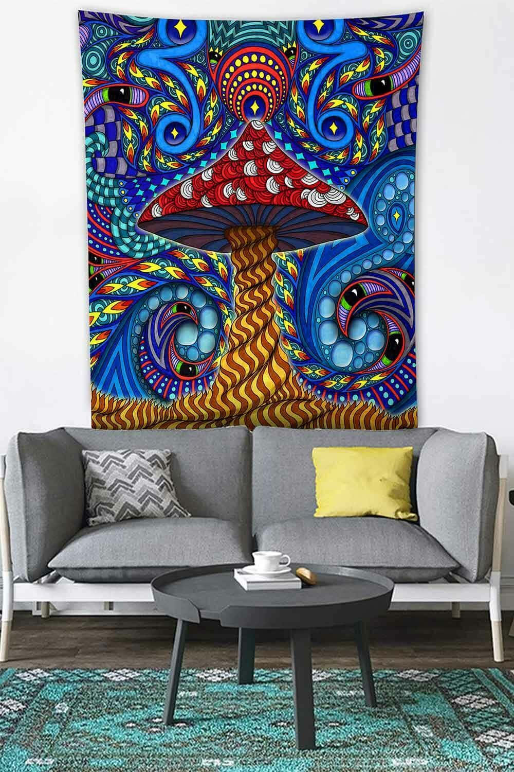 Trippy Mushrooms 桌布 壁紙 — 一幅充滿活力的迷幻掛毯，上面有紅色蘑菇和旋轉的藍色圖案，掛在現代客廳的灰色沙發上方。