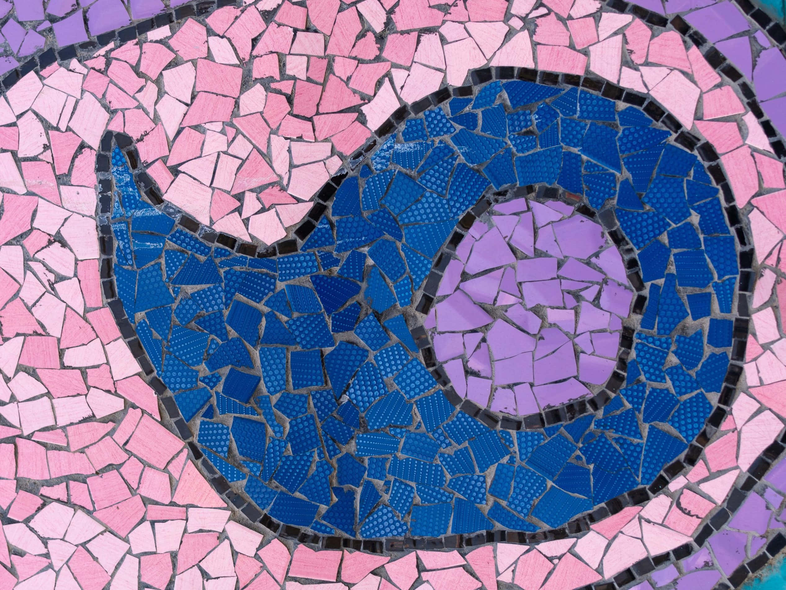 Mosaic 桌布 壁紙 — 一幅充滿活力的馬賽克藝術作品描繪了一條風格化的藍鯨在粉紅色瓷磚的海洋中游動，中心有一隻紫色的眼睛。