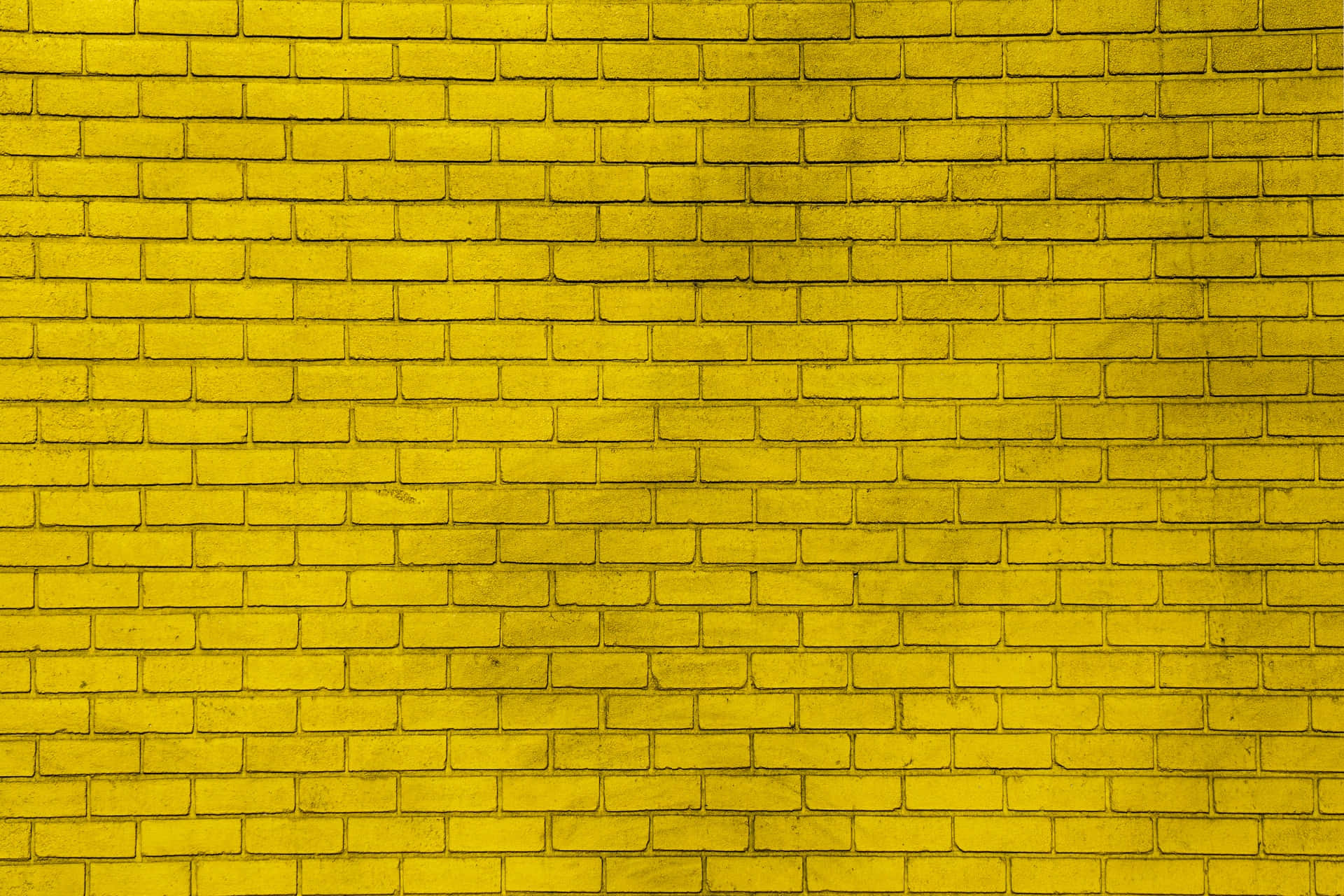 Yellow Pattern 桌布 壁紙 — 一幅充滿活力的黃色磚牆特寫，可見砂漿線條和細微的紋理變化。