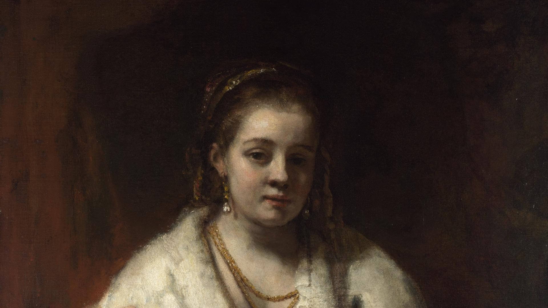 Rembrandt 桌布 壁紙 — 一幅古典油畫肖像，描繪一位年輕女性，身穿白色毛領，佩戴金色珠寶，背景為深色。