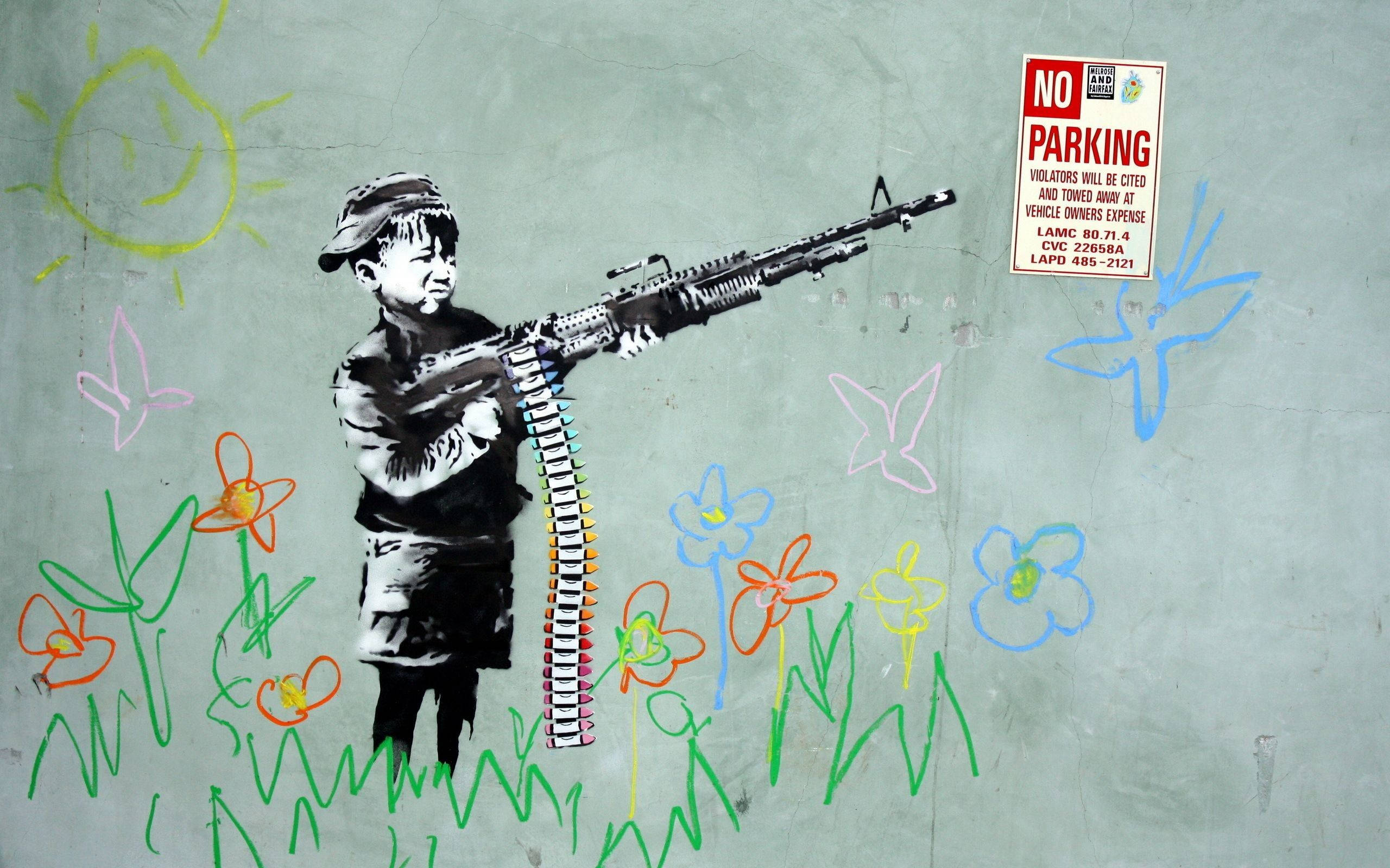 Banksy 桌布 壁紙 — 一幅塗鴉壁畫，描繪一個孩子在色彩繽紛的花朵和微笑的太陽中手持機關槍，畫在混凝土牆上。