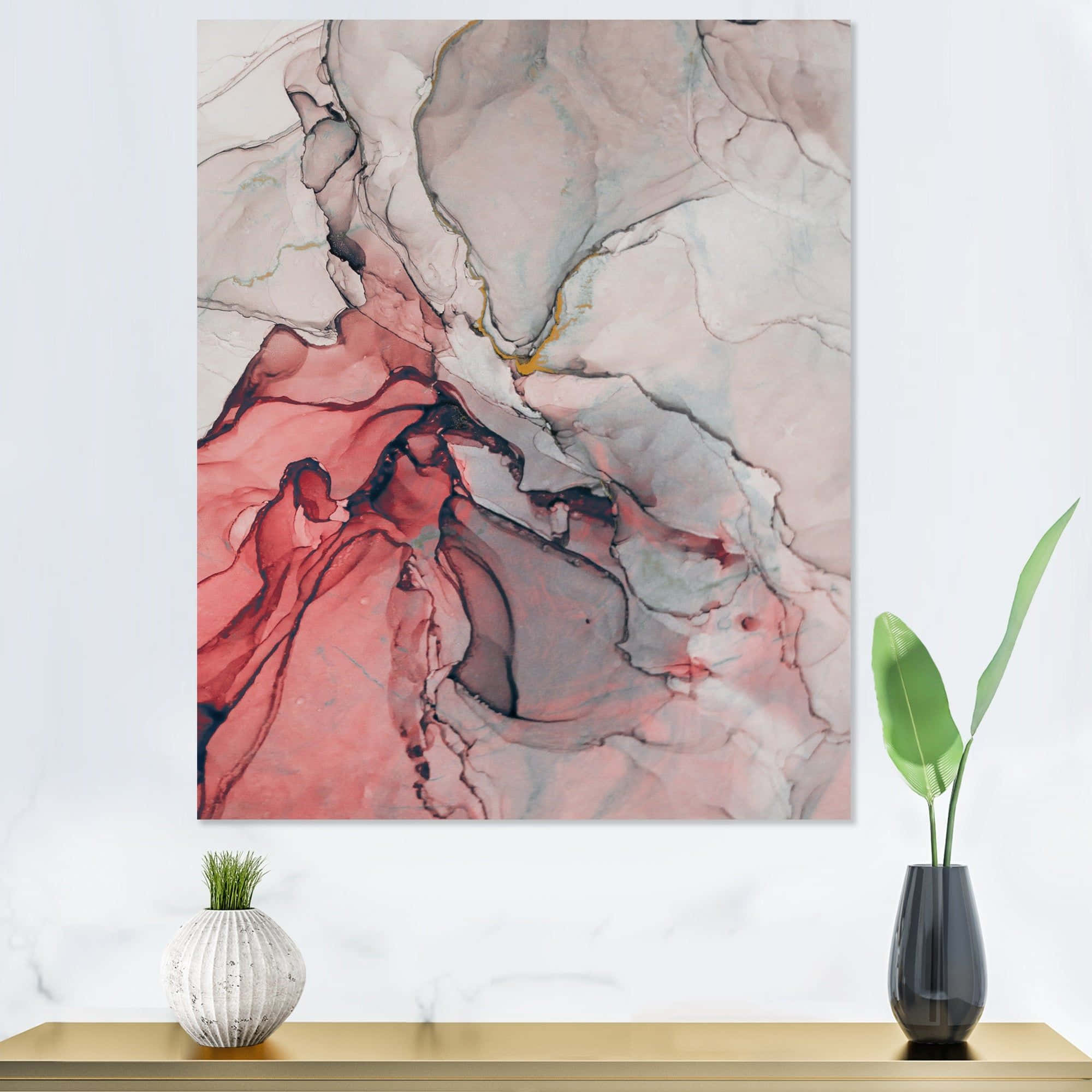 Red Marble 桌布 壁紙 — 一幅大型抽象畫，帶有流動的粉紅色、紅色和灰色色調，掛在白色牆壁上，下方金色架子上有兩盆盆栽植物。