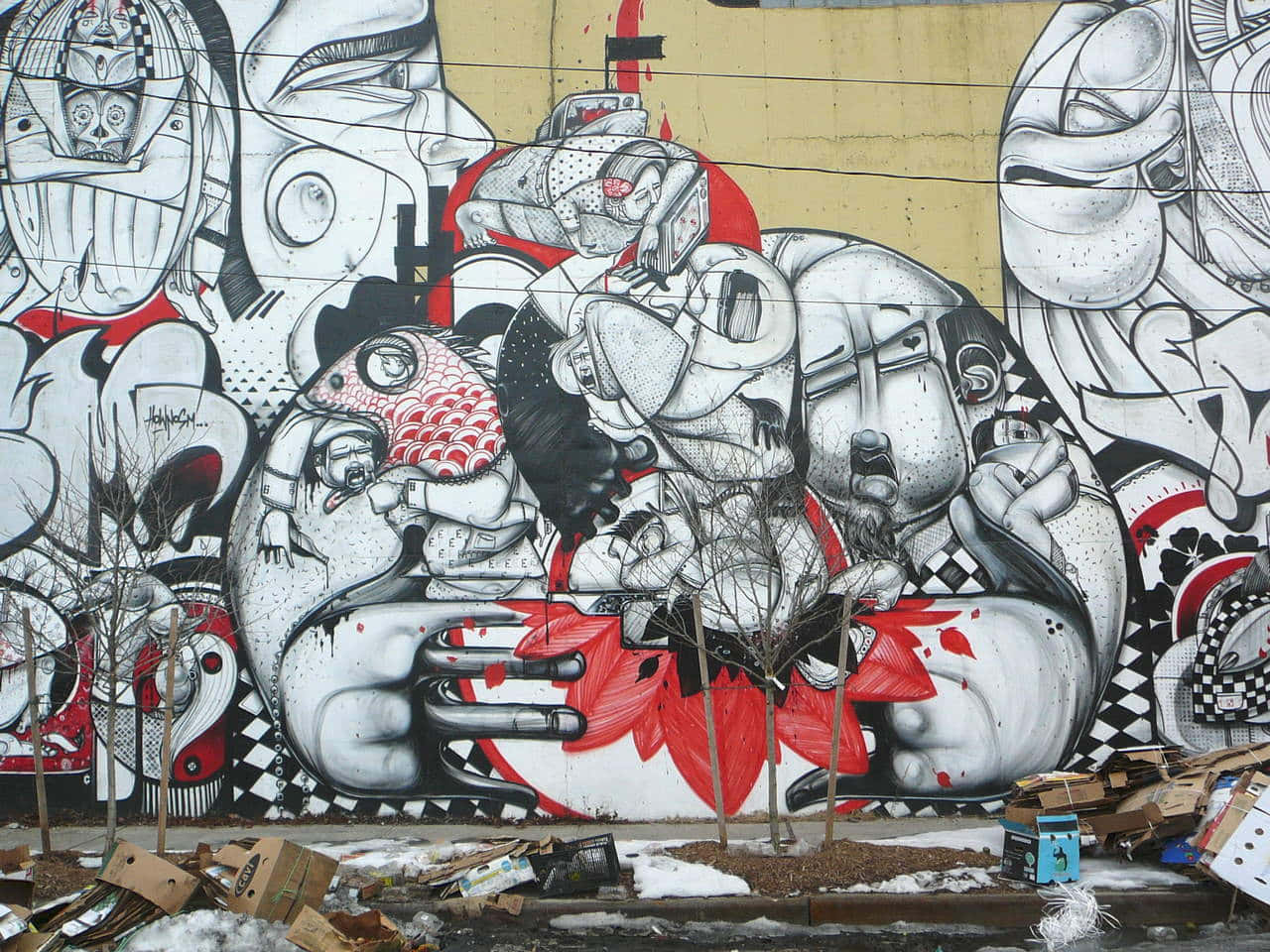 Black And White Graffiti 桌布 壁紙 — 一幅大型黑白紅三色抽象面孔與人物的塗鴉壁畫，主導著一面風化的城市牆壁，牆腳堆積著雪和垃圾。