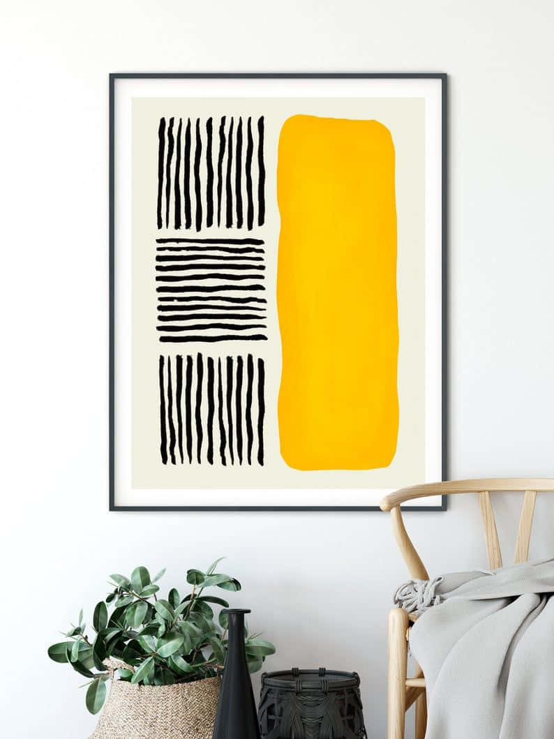 Modern Minimalist Art 桌布 壁紙 — 一幅帶有粗黑線條和鮮黃色塊的裱框抽象藝術品掛在白色牆上，旁邊有一張木椅和盆栽植物。