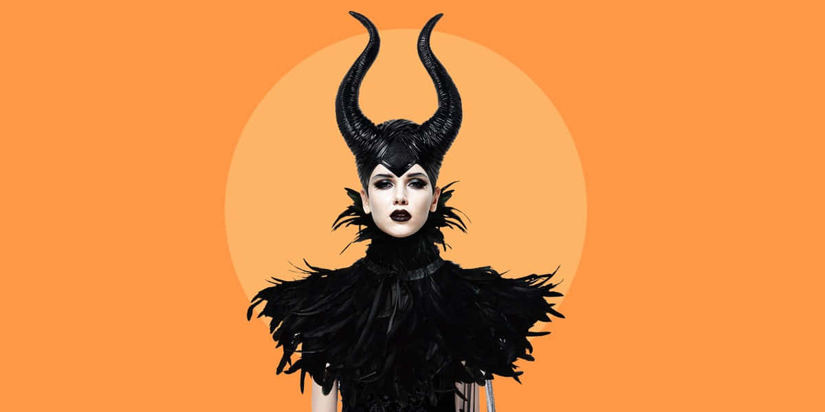 Horror Costumes 桌布 壁紙 — 一幅引人注目的肖像，一位女士戴著黑色角狀頭飾和羽毛服飾，背景是鮮明的橙色圓形。
