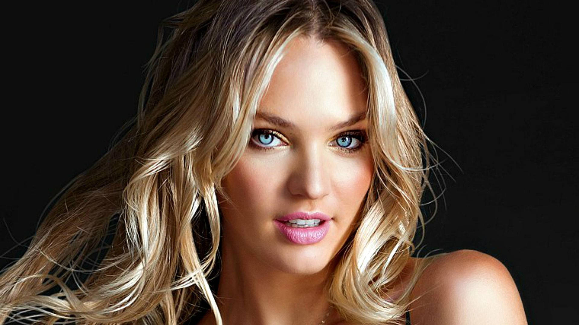 Candice 桌布 壁紙 — 一幅引人注目的肖像，金髮女子擁有銳利的藍色眼睛和柔軟的粉紅色嘴唇，背景是純黑色。