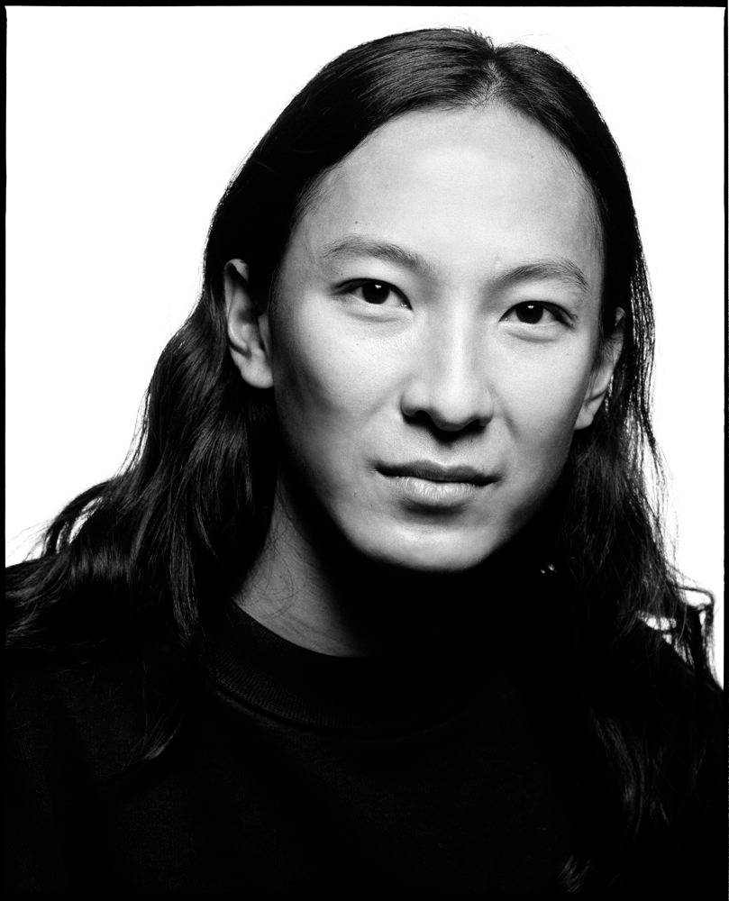 Alexander Wang 桌布 壁紙 — 一幅引人注目的黑白肖像，一位長黑髮的人直視鏡頭，背景為純白色。
