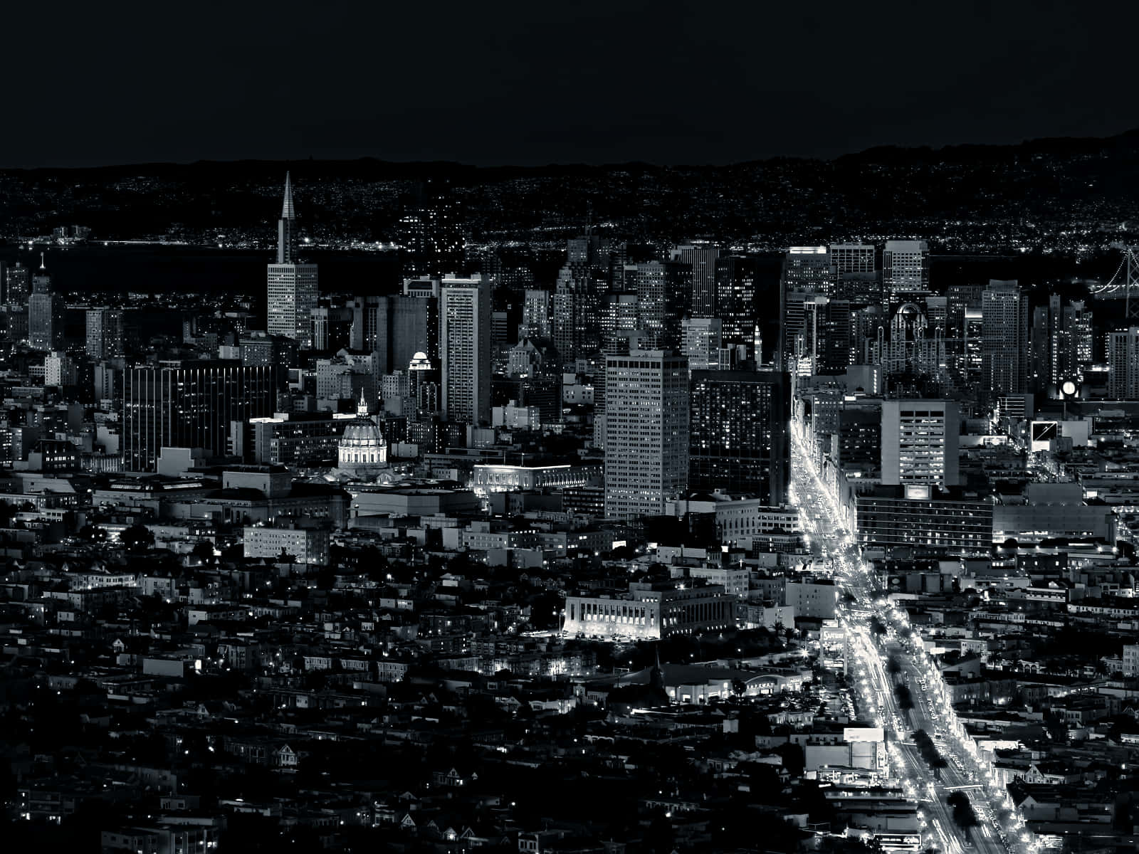 San Francisco Black And White 桌布 壁紙 — 一幅引人注目的黑白鳥瞰圖，展現夜晚燈火輝煌、照亮摩天大樓和蜿蜒街道的廣闊城市。