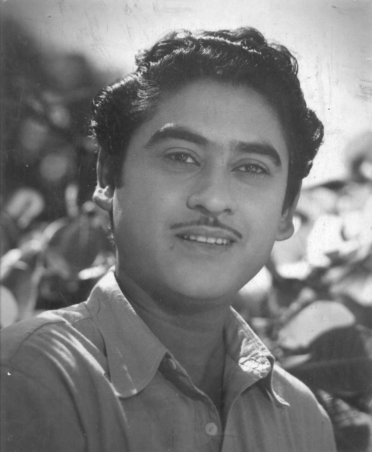 Kishore Kumar 桌布 壁紙 — 一幅復古黑白肖像，一位留鬍鬚、穿著有領襯衫的微笑男士。