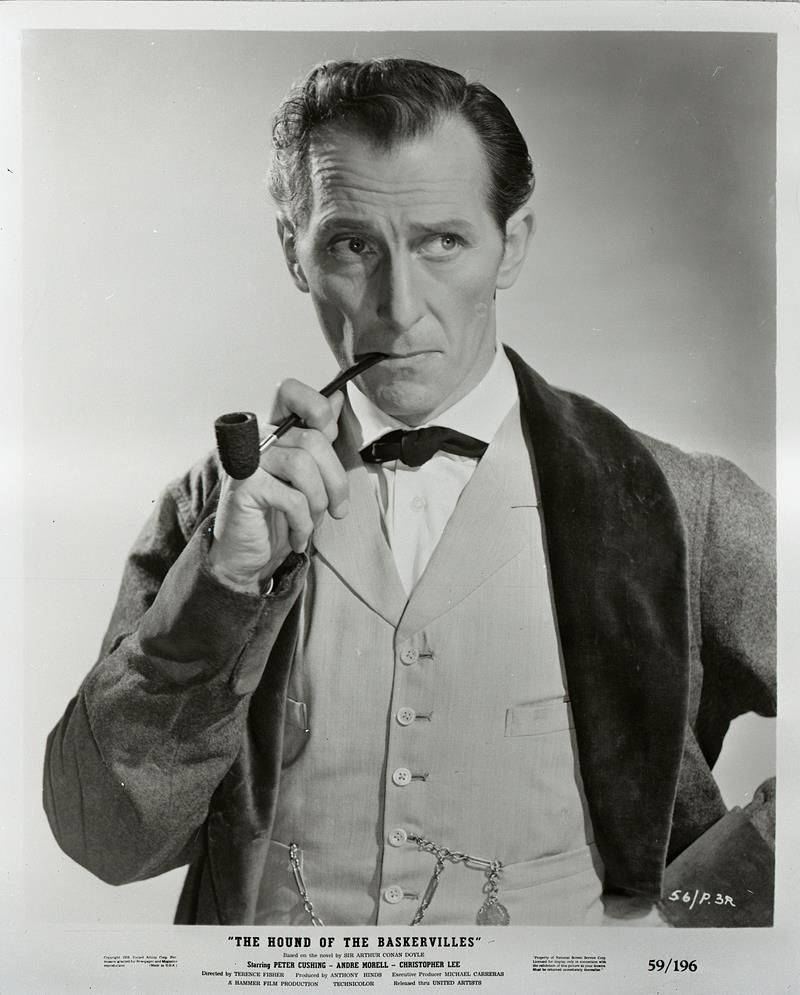 actor 桌布 壁紙 — 一幅復古黑白肖像，演員彼得·庫辛飾演夏洛克·福爾摩斯，手持煙斗，表情嚴肅。