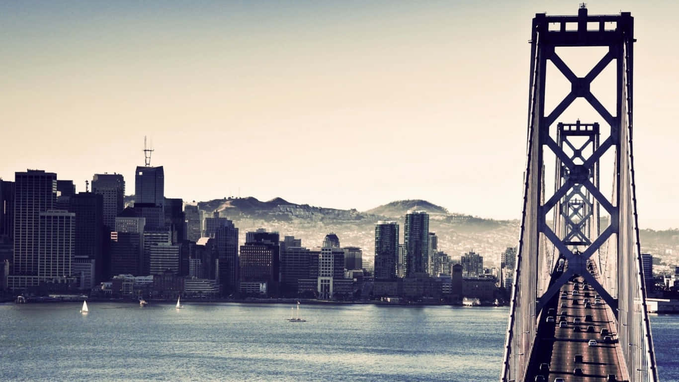 1366x768 San Francisco 桌布 壁紙 — 一幅懷舊色調的海灣大橋景色，通往煙霧瀰漫的舊金山天際線，水面上有帆船。