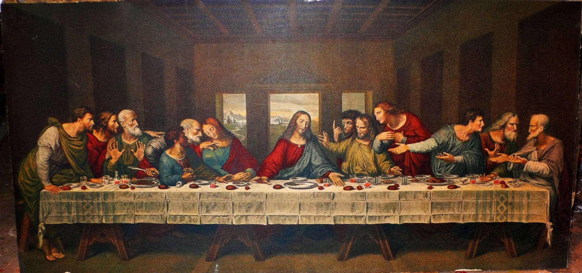 Christ 桌布 壁紙 — 一幅戲劇性的宗教畫描繪耶穌和祂的門徒聚集在一張長桌旁，在昏暗的房間裡，表情強烈，身穿華麗長袍。