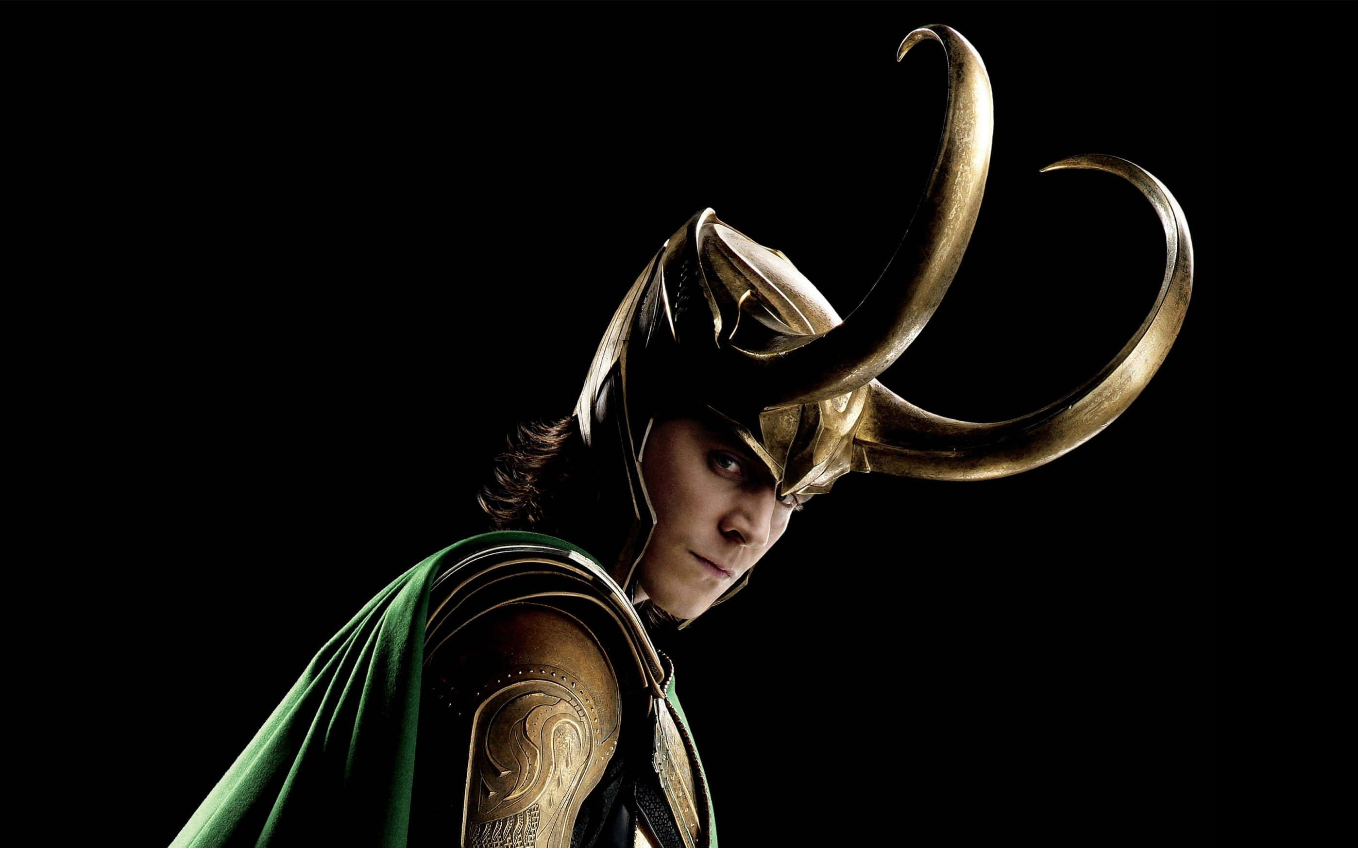 Marvel Loki 桌布 壁紙 — 一幅戲劇性的洛基肖像，他戴著標誌性的金色角盔和綠色斗篷，背景是純黑色。