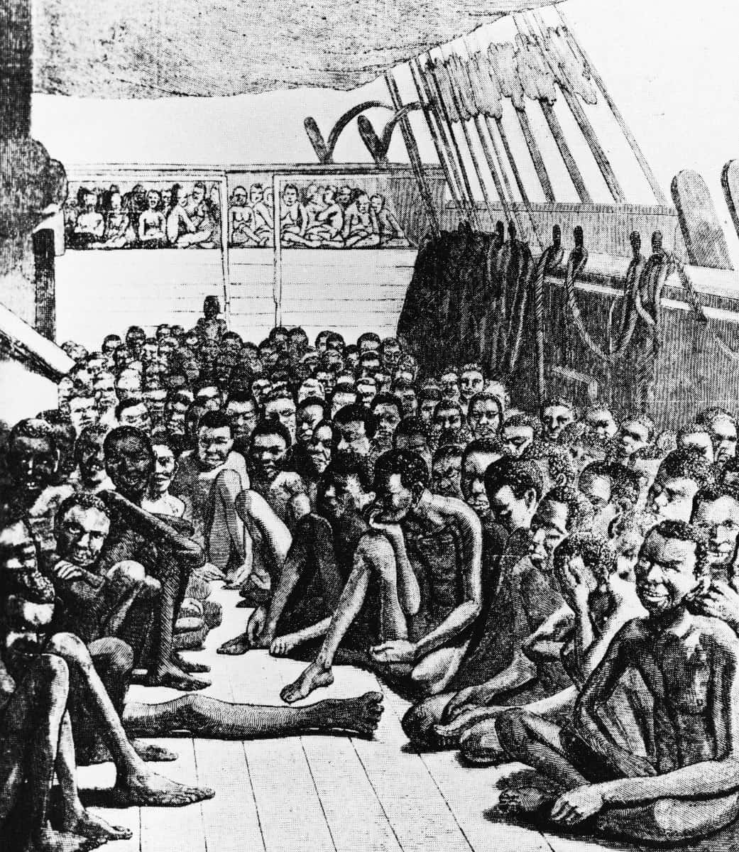 Slave 桌布 壁紙 — 一幅擁擠的歷史插圖，描繪了被奴役的人在惡劣條件下緊密擠在船甲板上的情景。