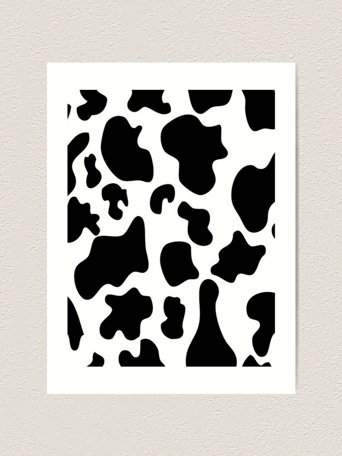 Aesthetic Cow 桌布 壁紙 — 一幅極簡黑白乳牛紋圖案藝術印刷品，安裝在帶有紋理的米白色牆上。