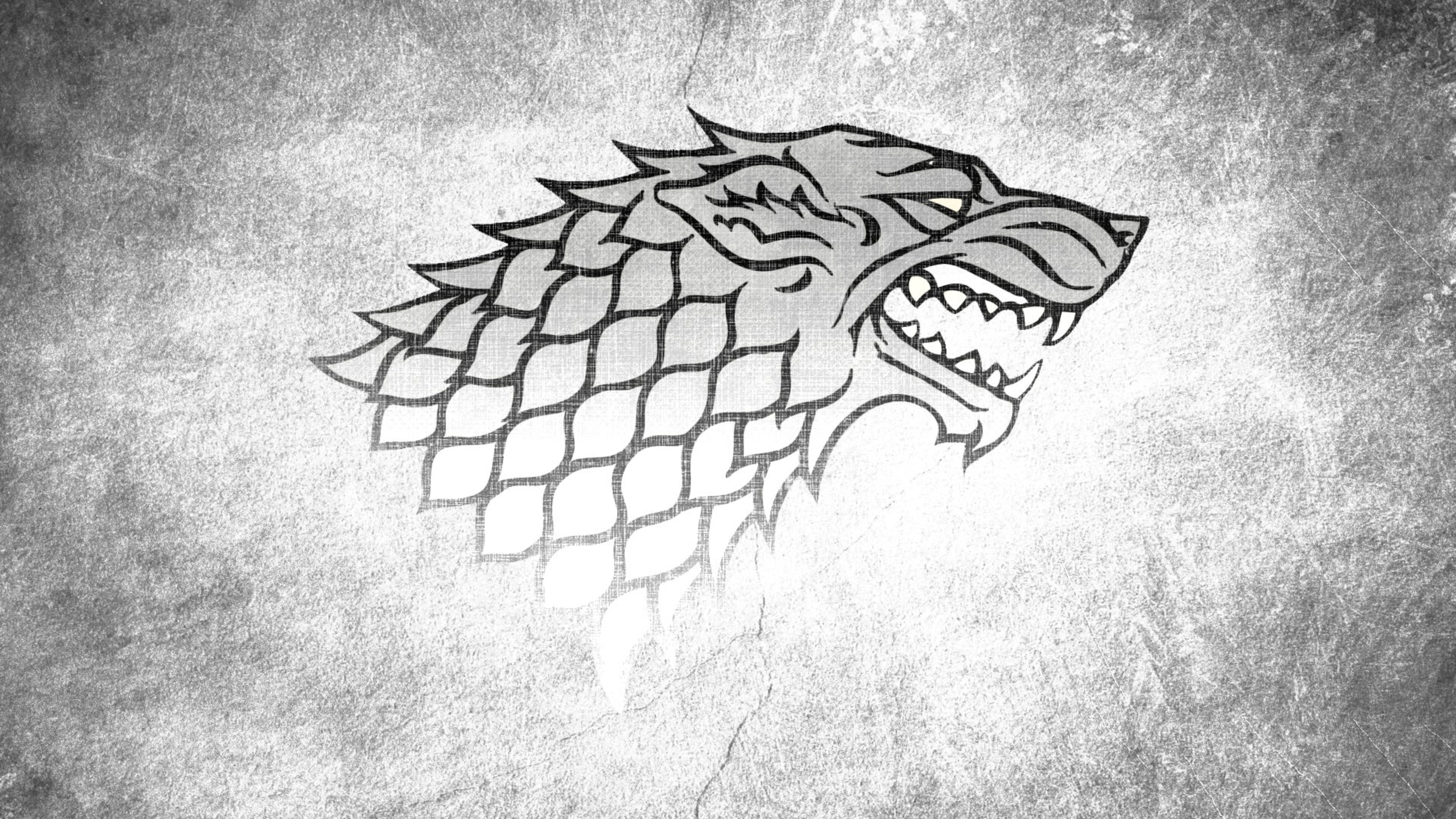 House Stark 桌布 壁紙 — 一幅清晰的黑白插圖，描繪一隻咆哮的冰原狼頭部，頸部有菱形圖案，背景為風化的混凝土。