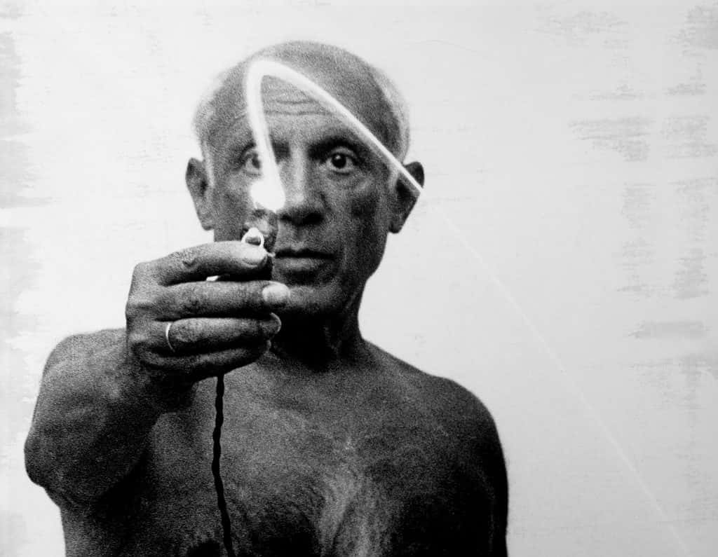Picasso 桌布 壁紙 — 一幅清晰的黑白肖像，描繪一位老人手持冒煙的香煙，頭頂有一道發光的軌跡劃過。