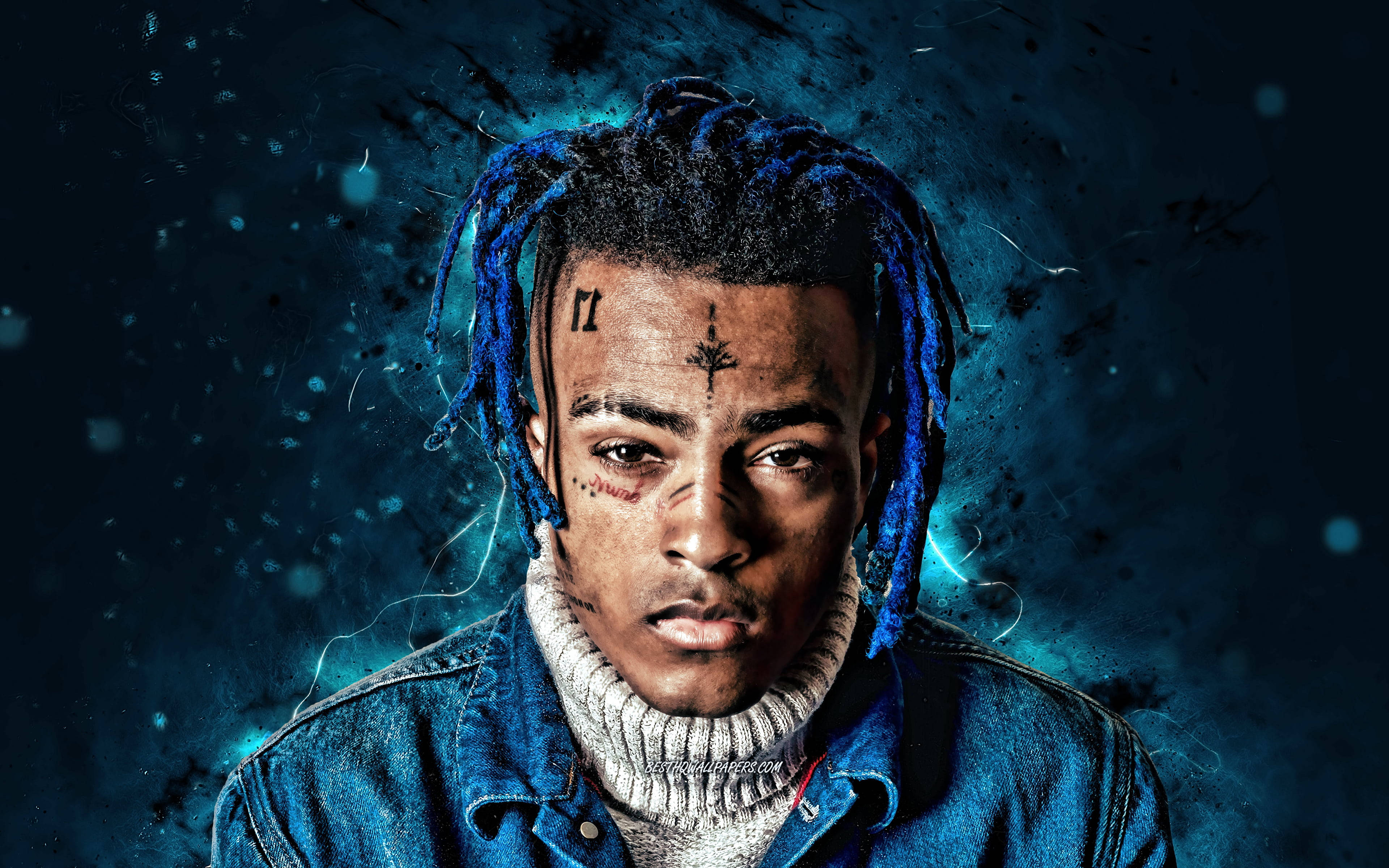 xxxtentacion 電腦 桌布 壁紙 — 一幅男子肖像，擁有藍色辮子頭和臉部刺青，背景為深電光藍色，帶有發光粒子。