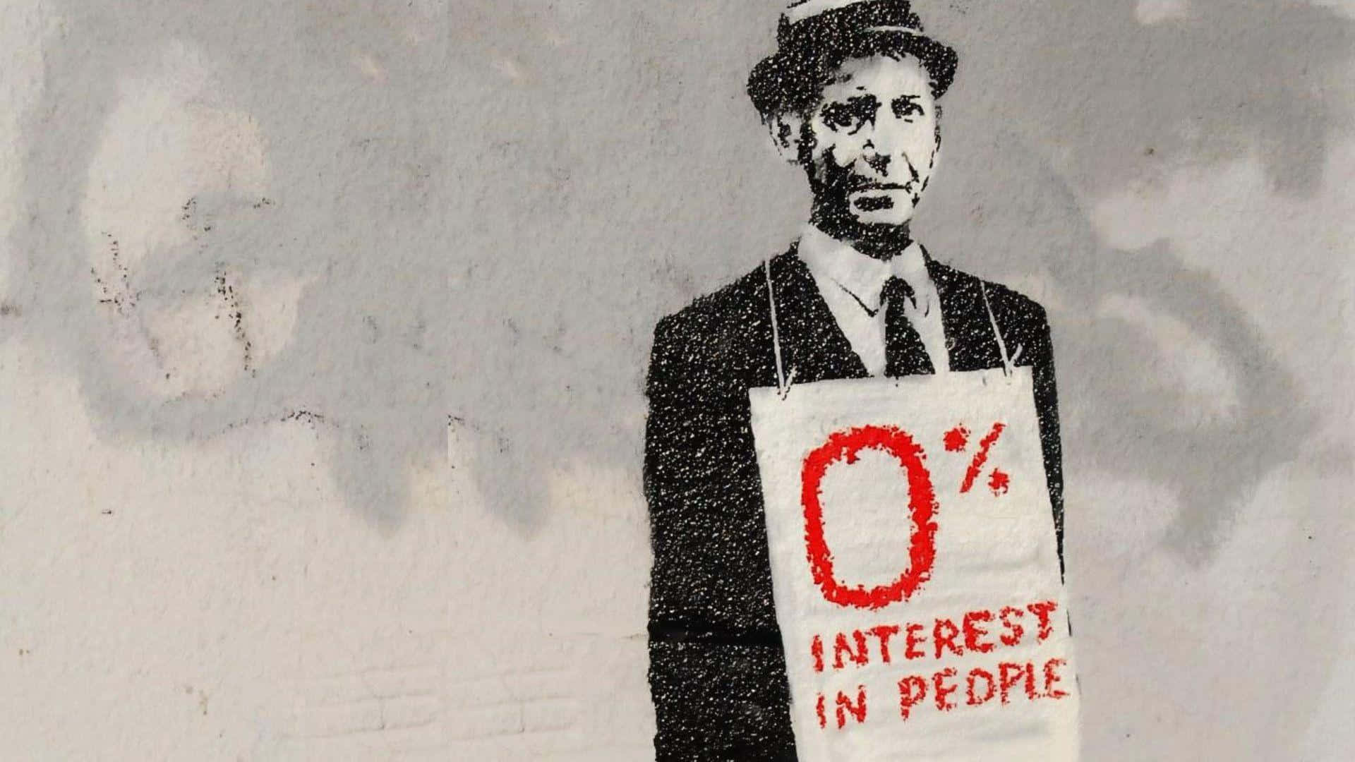 Banksy 桌布 壁紙 — 一幅粗糙的模板塗鴉，描繪一個穿著西裝戴帽子的男人，在風化的牆壁前舉著一塊寫有「0% INTEREST IN PEOPLE」的牌子。