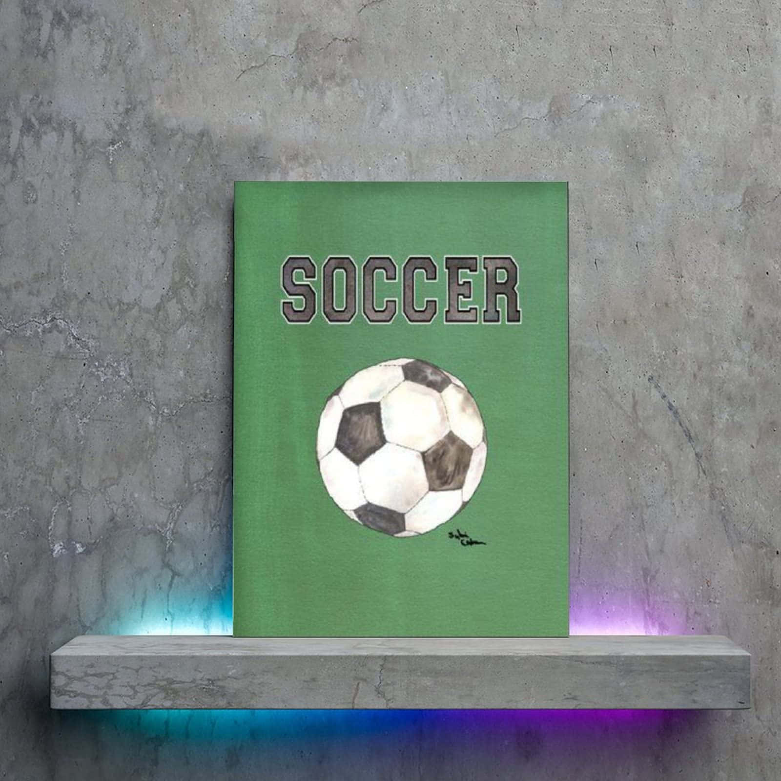 Minimalist Sports 桌布 壁紙 — 一幅綠色畫布上繪有足球和「足球」字樣的畫作，懸掛在混凝土牆上，下方是帶燈光的層架。