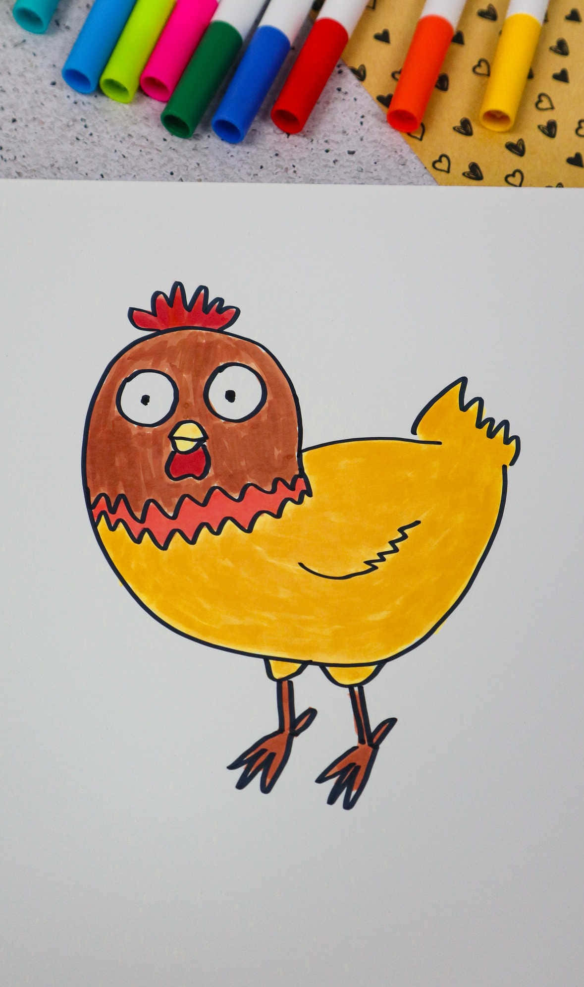 coloring 桌布 壁紙 — 一幅色彩繽紛的卡通雞繪畫，帶有粗線條和馬克筆陰影，放在白紙上，旁邊是鮮豔的馬克筆和圖案紙。