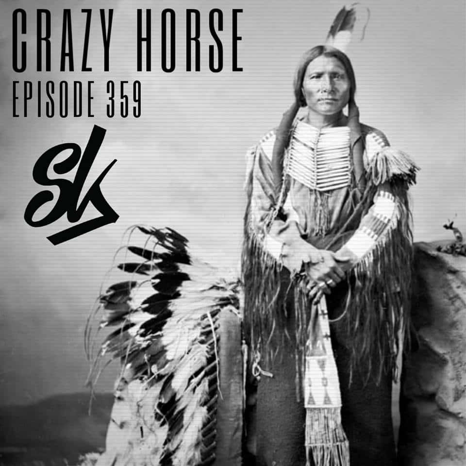 Crazy Horse 桌布 壁紙 — 一幅莊嚴的黑白肖像畫，描繪了瘋馬穿著傳統服飾，手持羽毛頭飾。