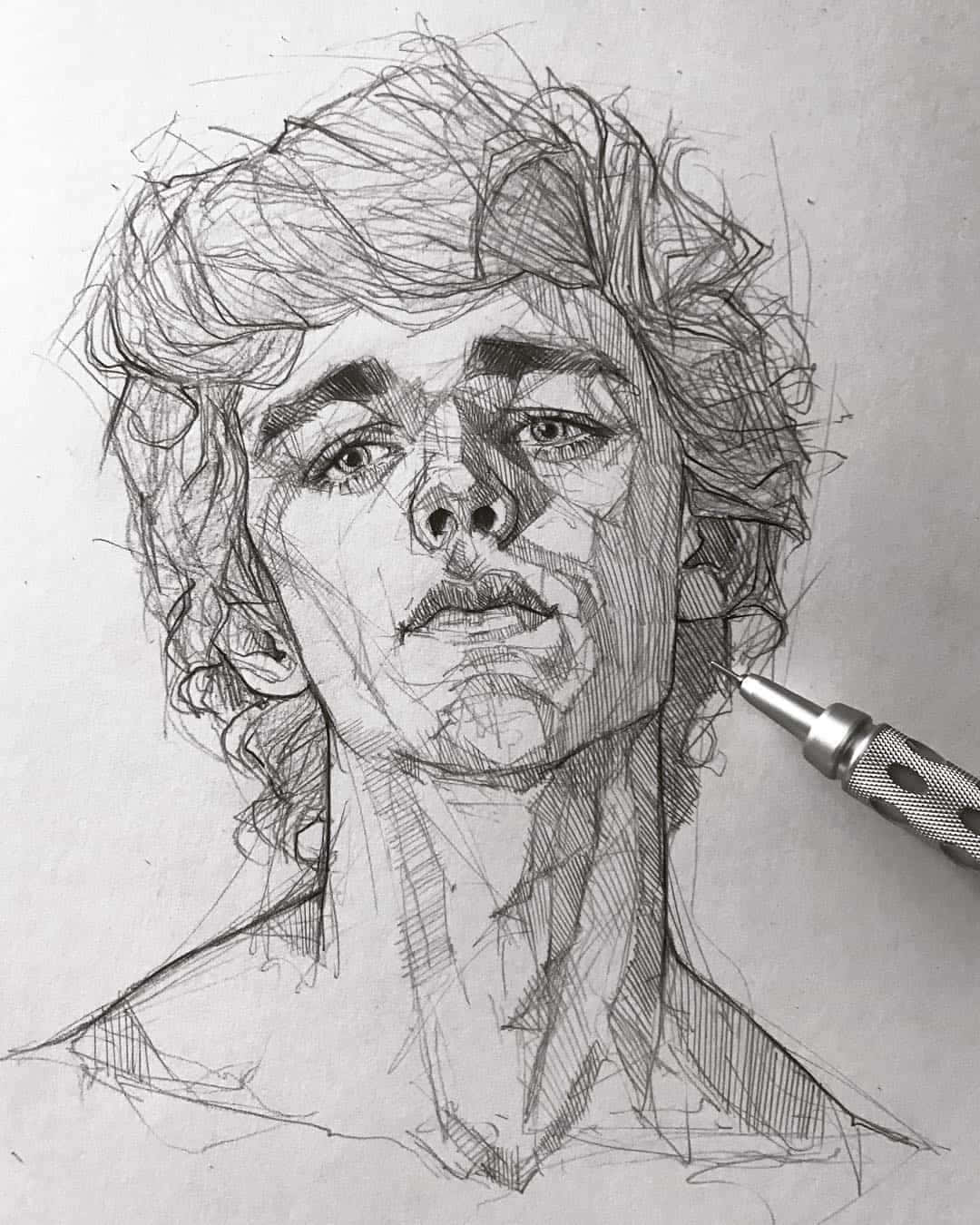 Sketch Art 桌布 壁紙 — 一幅詳細的鉛筆素描，描繪一位擁有捲髮和銳利眼神的年輕男子，一支筆擱在他的肩膀附近。