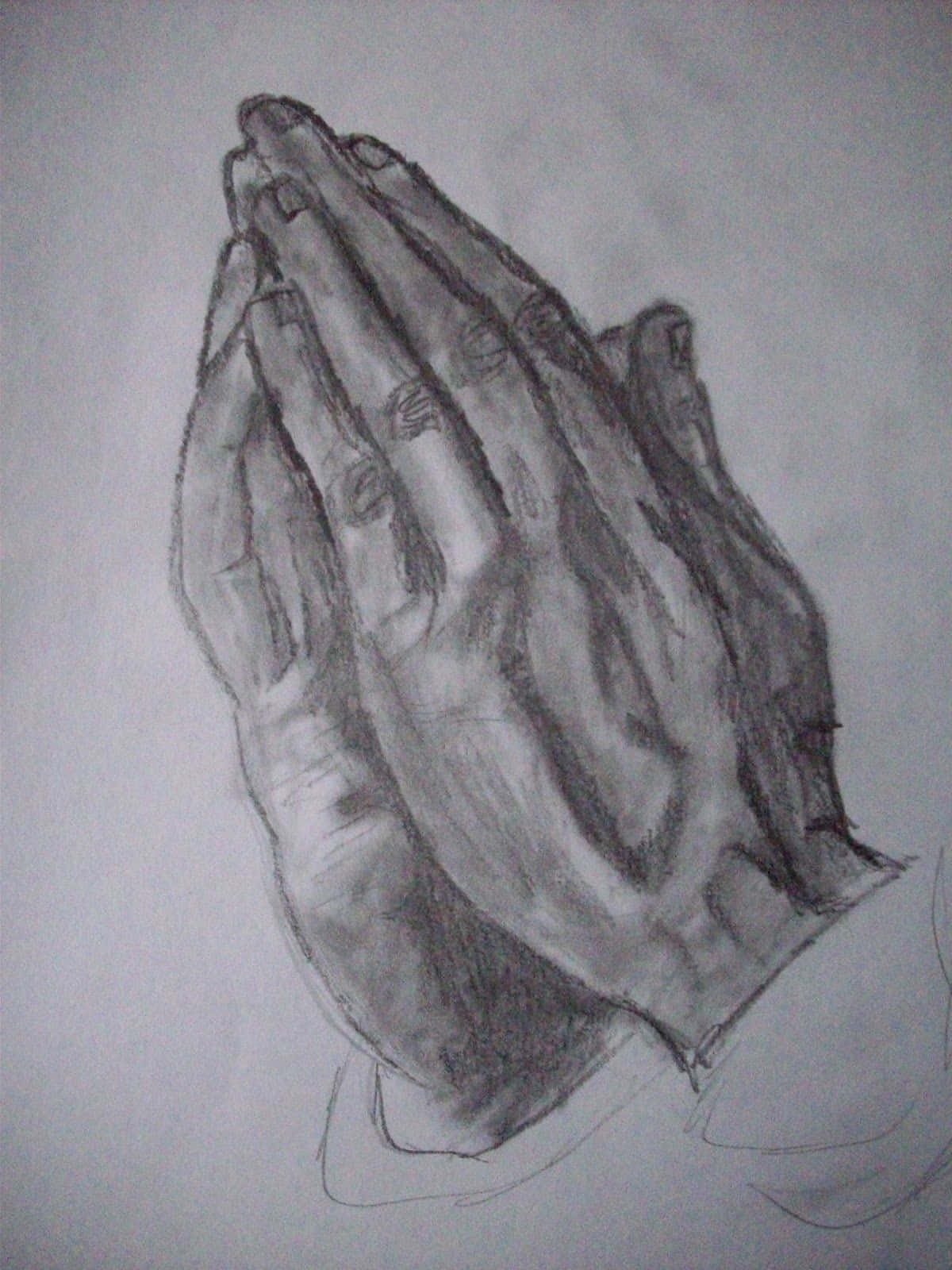 Praying 桌布 壁紙 — 一幅詳細的鉛筆素描，描繪兩隻手合十祈禱，帶有強烈的陰影和紙上可見的紋理。
