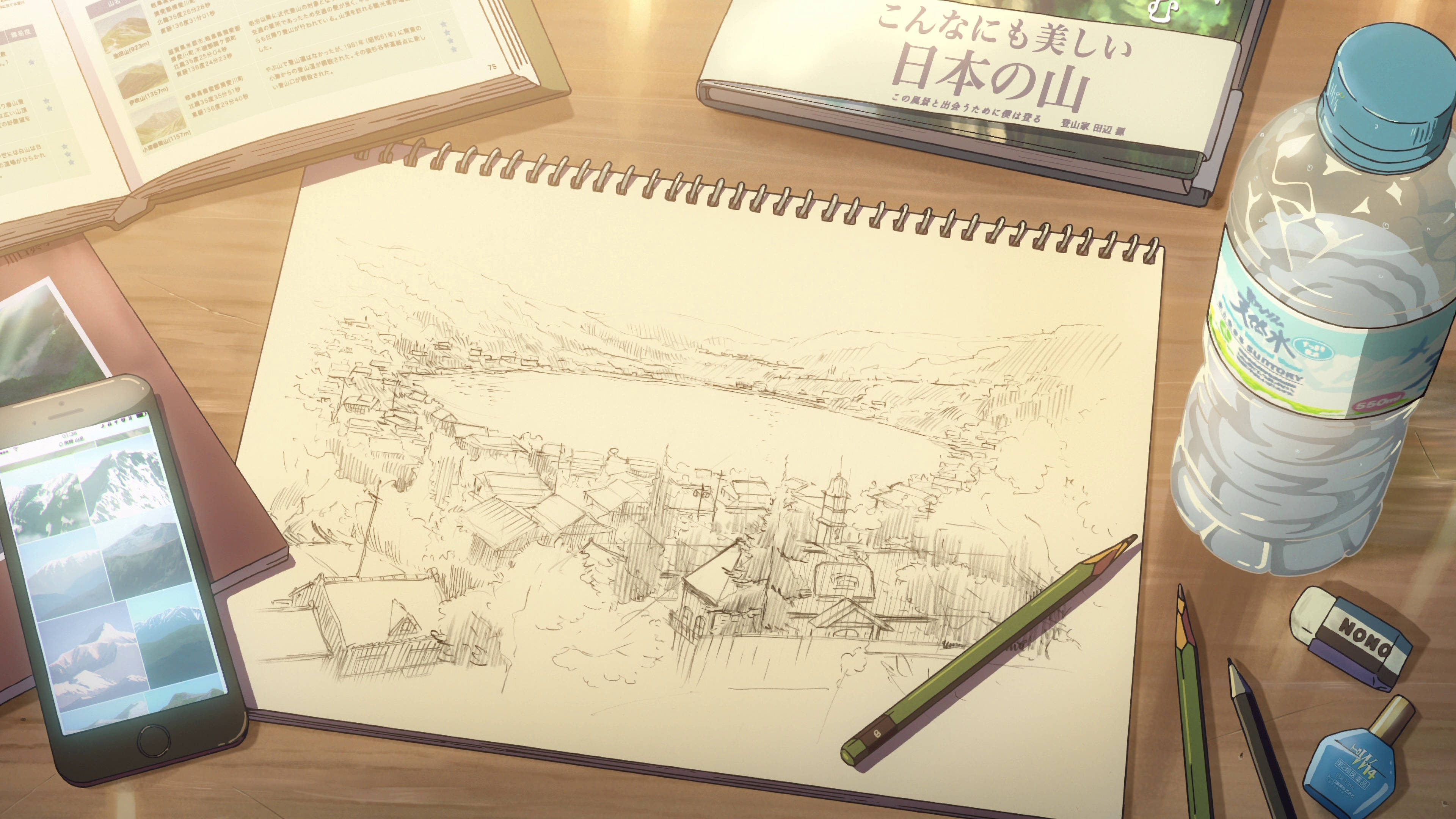 動漫 4K 桌布 壁紙 — 一幅詳細的鉛筆素描描繪了一個山村，放在木桌上，旁邊有美術用品和一個水瓶。