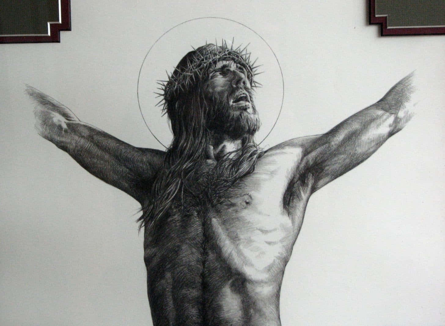 Jesus Crucifixion 桌布 壁紙 — 一幅詳細的黑白畫作，描繪耶穌基督戴著荊棘冠冕和光環，雙臂張開在白色牆壁上。