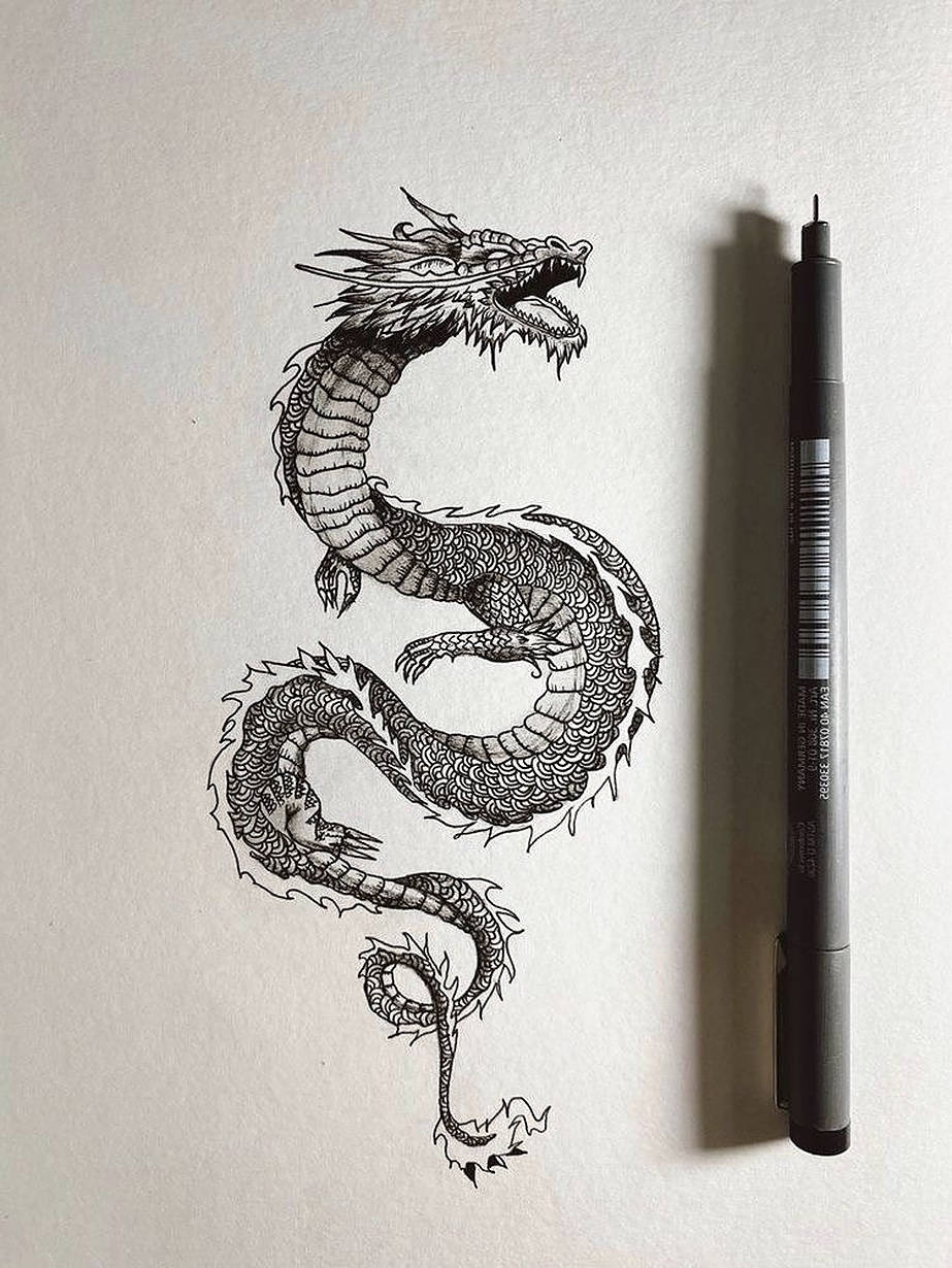 Japanese Dragon Tattoo 桌布 壁紙 — 一幅詳細的黑色墨水龍畫，在紋理紙上盤成S形，旁邊有一支黑色馬克筆。