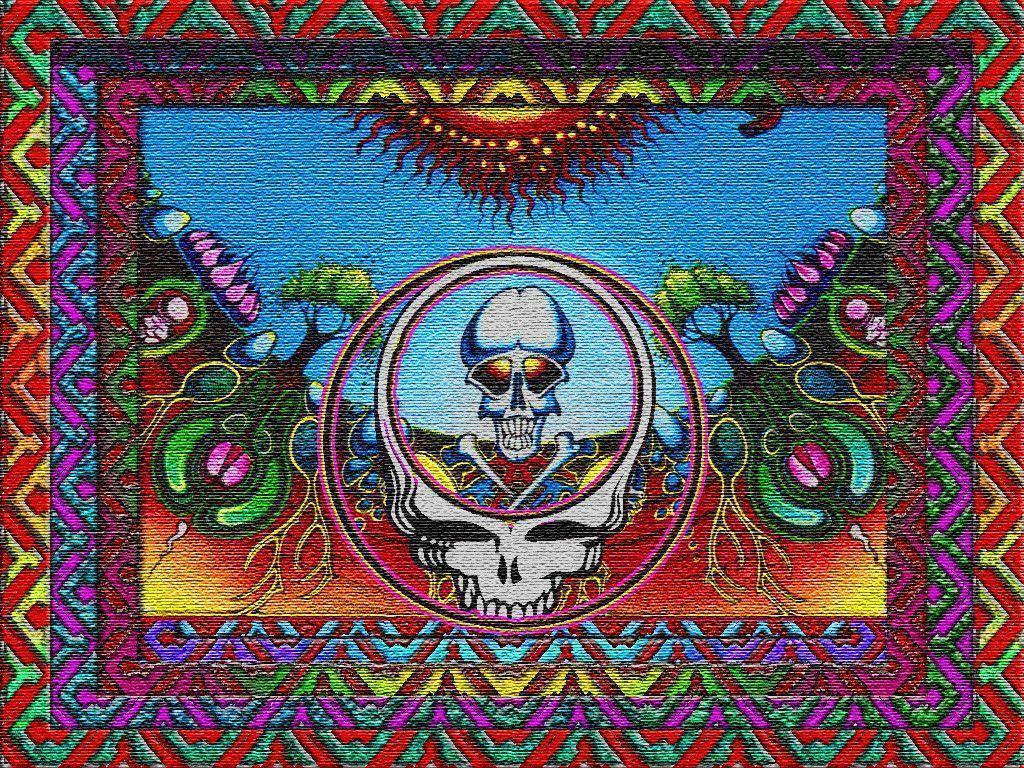 dead 桌布 壁紙 — 一幅迷幻插圖，中央有一個帶彩虹眼睛的骷髏頭，周圍環繞著鮮豔的幾何邊框和超現實植物，在陽光下呈現。