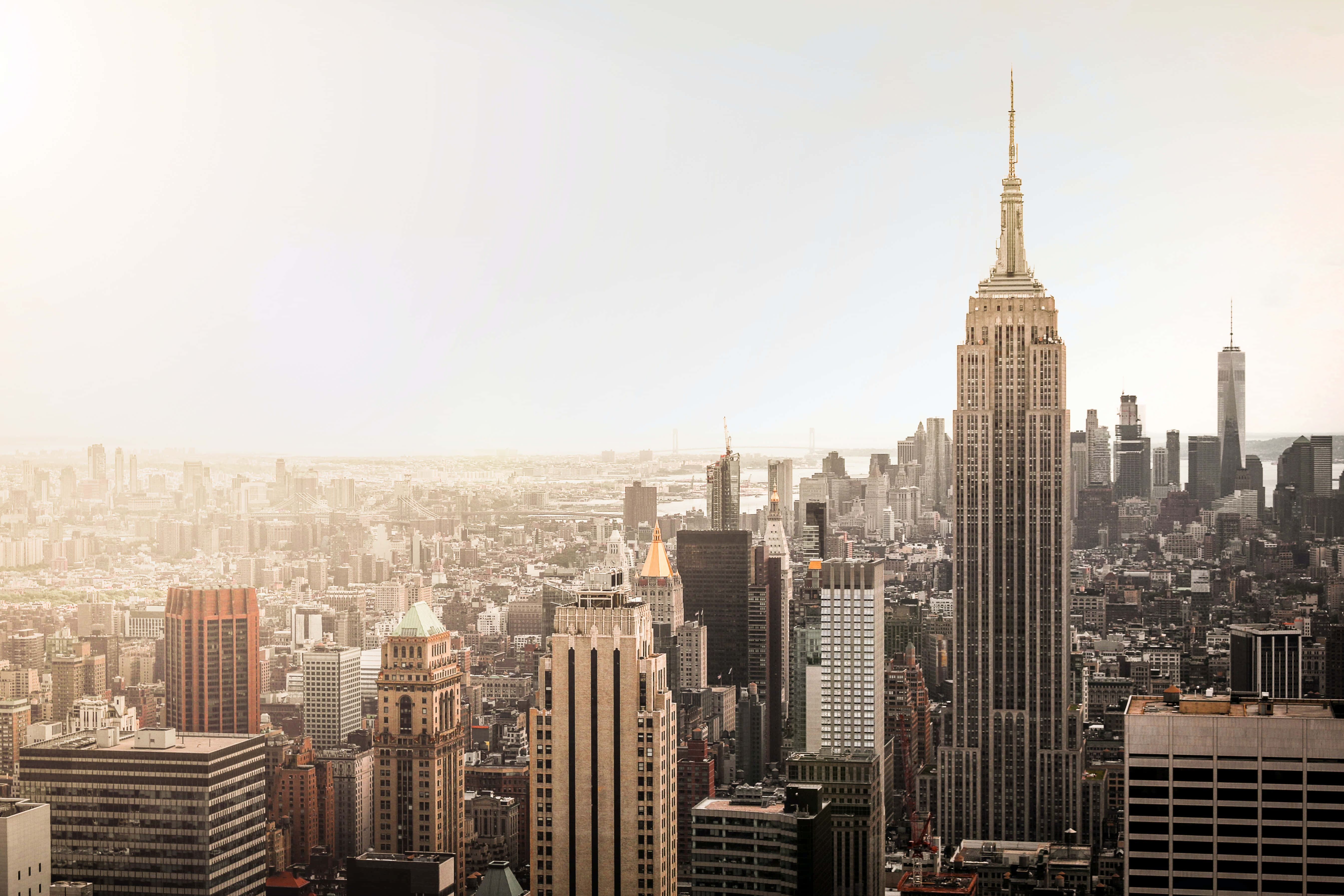 Empire State Building 桌布 壁紙 — 一幅金色調的紐約市天際線鳥瞰圖，以日出時的帝國大廈為主導。