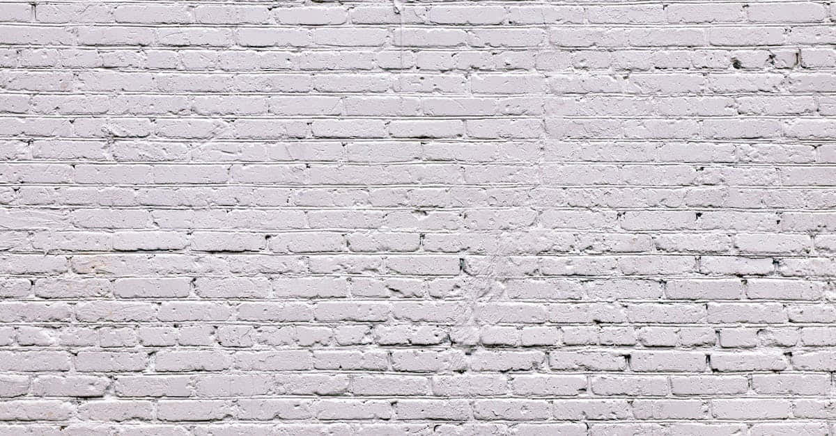 White Brick Wall 桌布 壁紙 — 一幅風化白色磚牆的特寫，可見砂漿線條和細微的紋理變化。