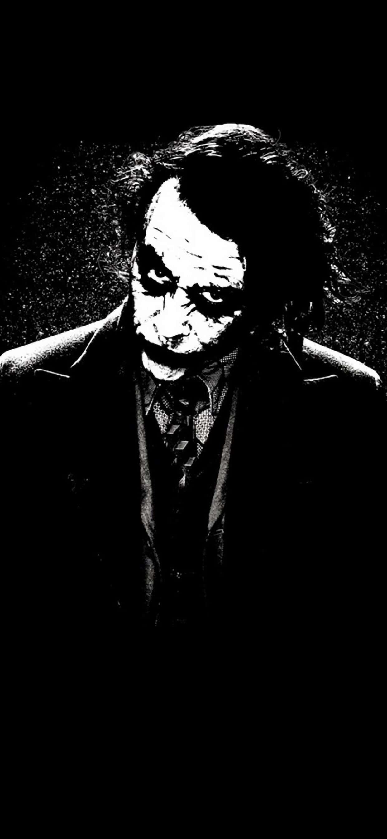 Batman Black And White 桌布 壁紙 — 一幅高對比度的黑白插圖，描繪小丑在黑暗背景中露出邪惡的笑容和凌亂的頭髮。