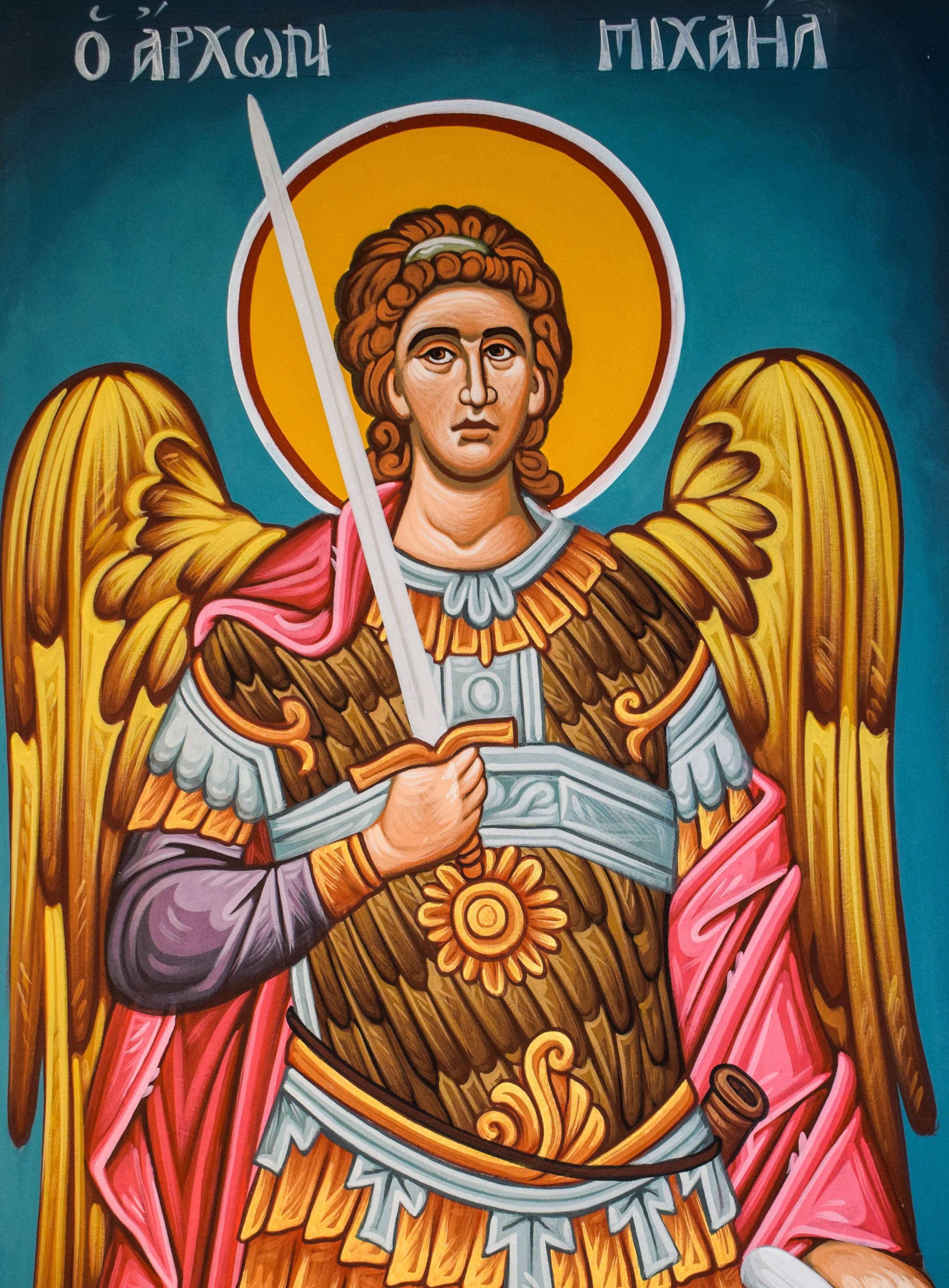 angels 桌布 壁紙 — 一幅鮮明的宗教聖像，描繪大天使米迦勒，擁有金色翅膀和劍，背景為深青色並帶有希臘文字。