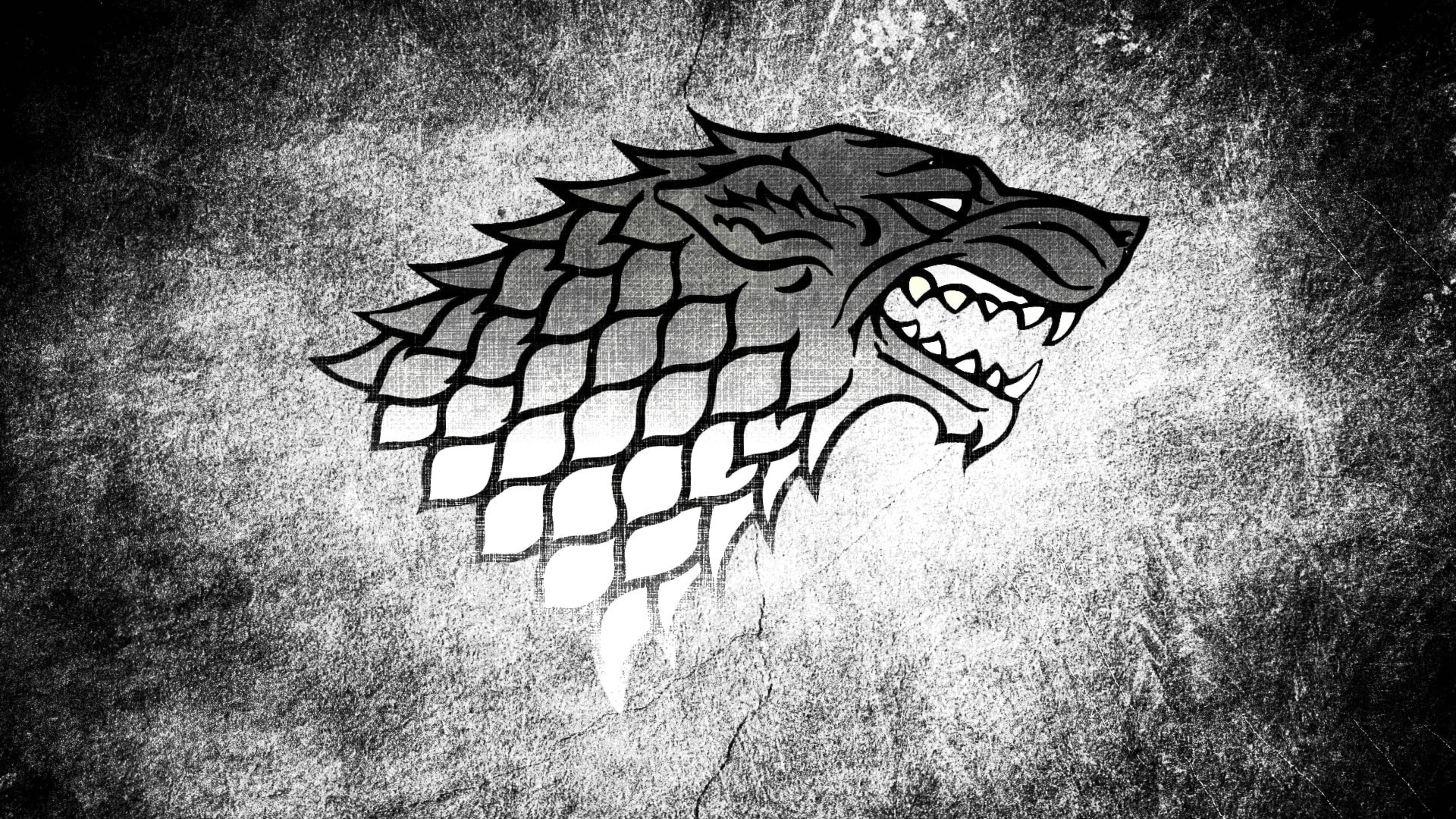 House Stark 桌布 壁紙 — 一幅鮮明的黑白插圖，描繪一隻咆哮的冰原狼頭部，戴著尖刺項圈，背景粗糙有紋理。