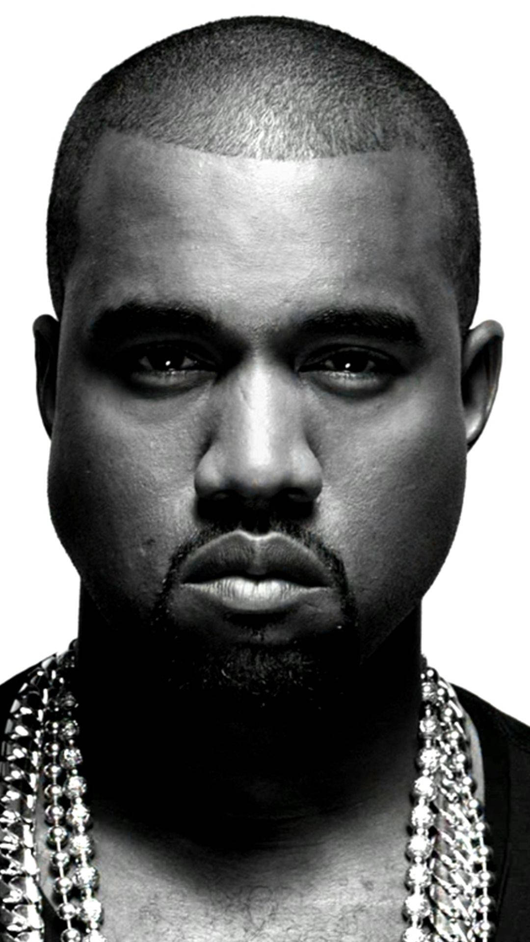 Kanye West 桌布 壁紙 — 一幅鮮明的黑白肖像，Kanye West 帶有強烈的眼神和鑲鑽鏈條，背景簡潔。