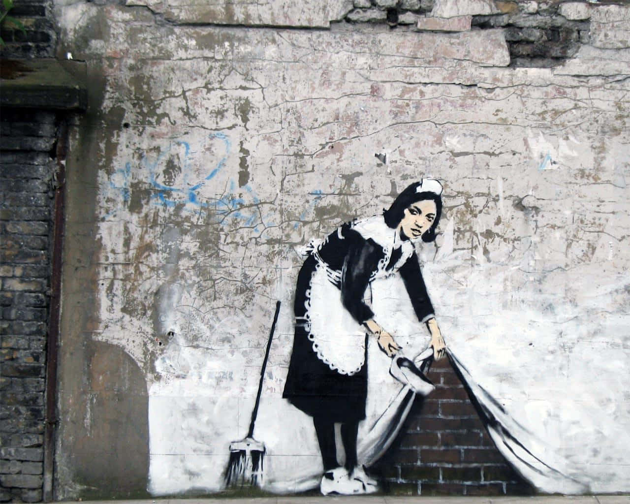 Banksy 桌布 壁紙 — 一幅鮮明的黑白街頭壁畫描繪一名女僕拉開窗簾，露出背後的磚牆。