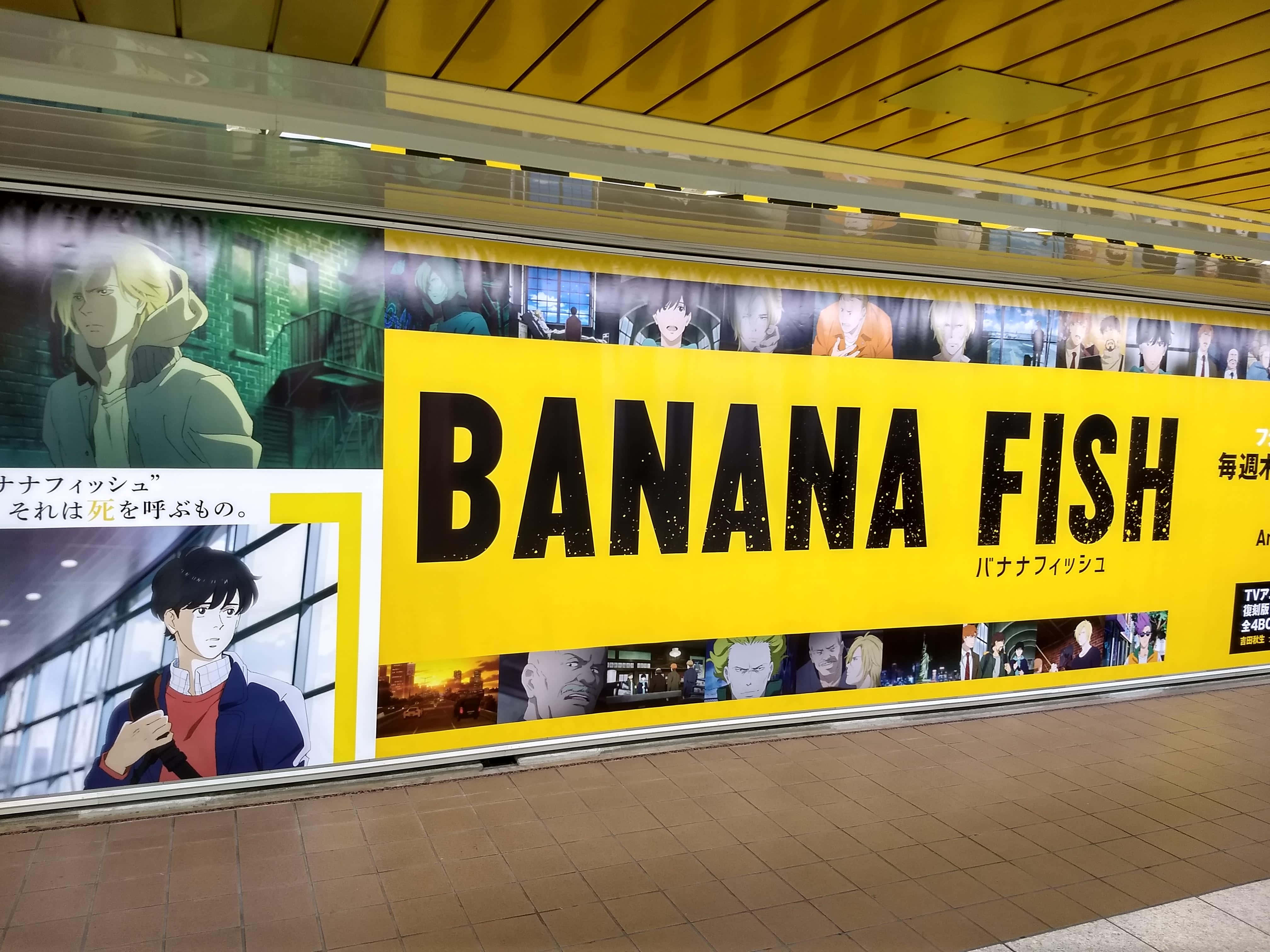 Banana Fish 桌布 壁紙 — 一幅鮮黃色的《Banana Fish》動畫廣告牌在木天花板下的瓷磚地鐵站月台上佔據主導地位。
