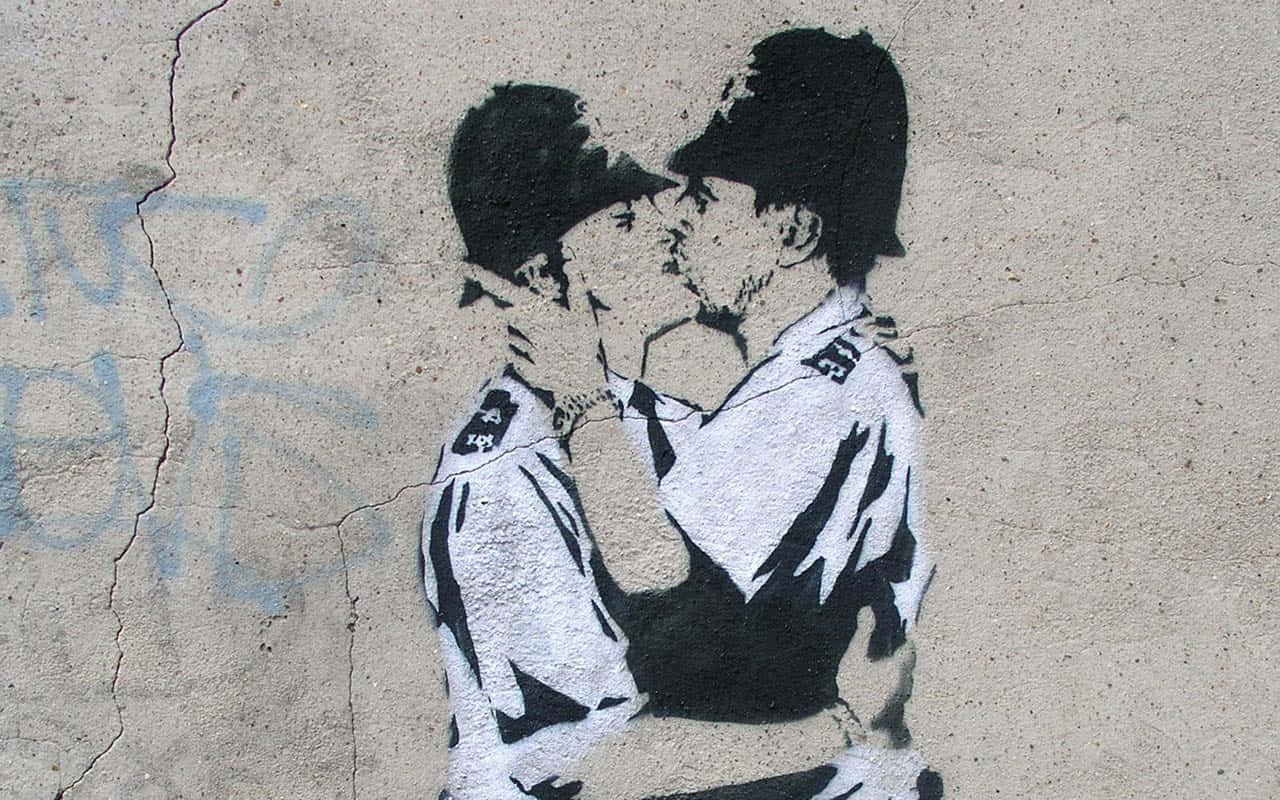 Banksy 桌布 壁紙 — 一幅黑白模板塗鴉描繪了兩名警察在破裂的混凝土牆上激情接吻。