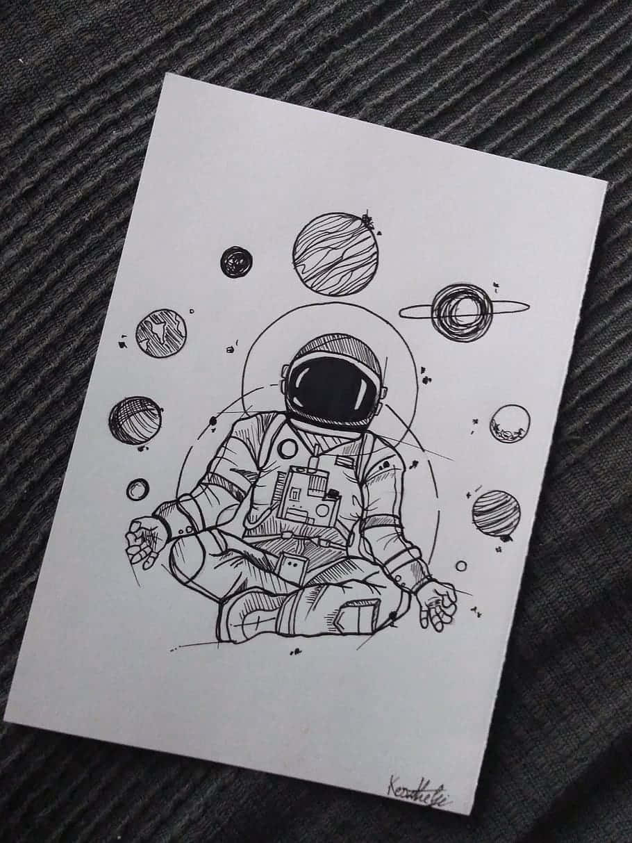 Sketches 桌布 壁紙 — 一幅黑白線條畫，描繪一名太空人在傾斜的紙張上，於風格化的行星之間冥想，紙張放在條紋布料上。