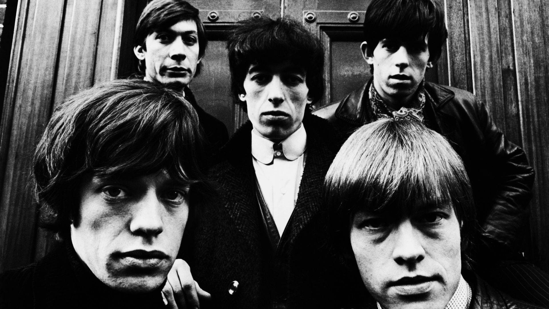 Rock 桌布 壁紙 — 一幅黑白肖像，The Rolling Stones 樂團成員在木門背景下凝視鏡頭。
